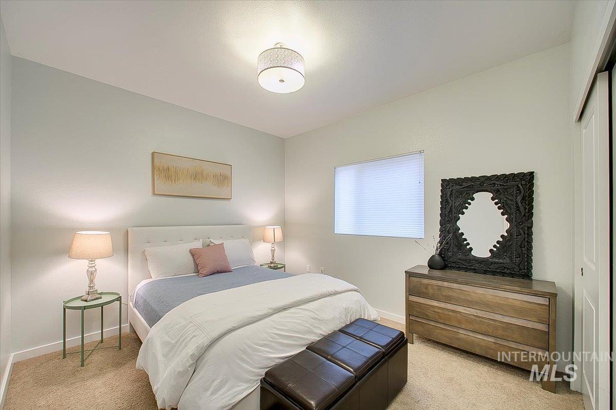 Bedroom with light colored carpet and baseboards