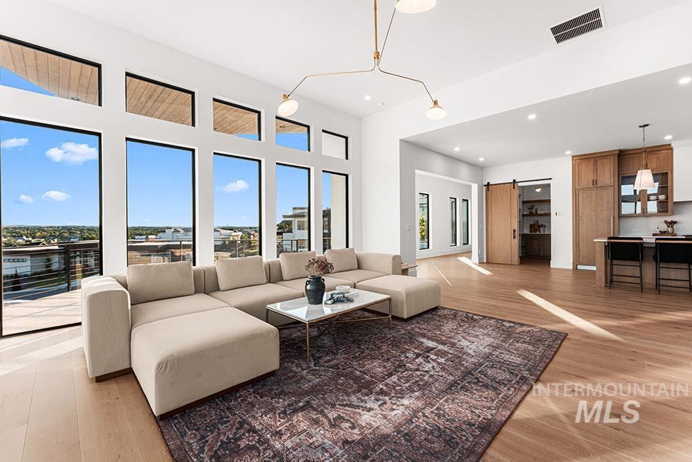Living room featuring a barn door, light wood-style floors, and recessed lighting