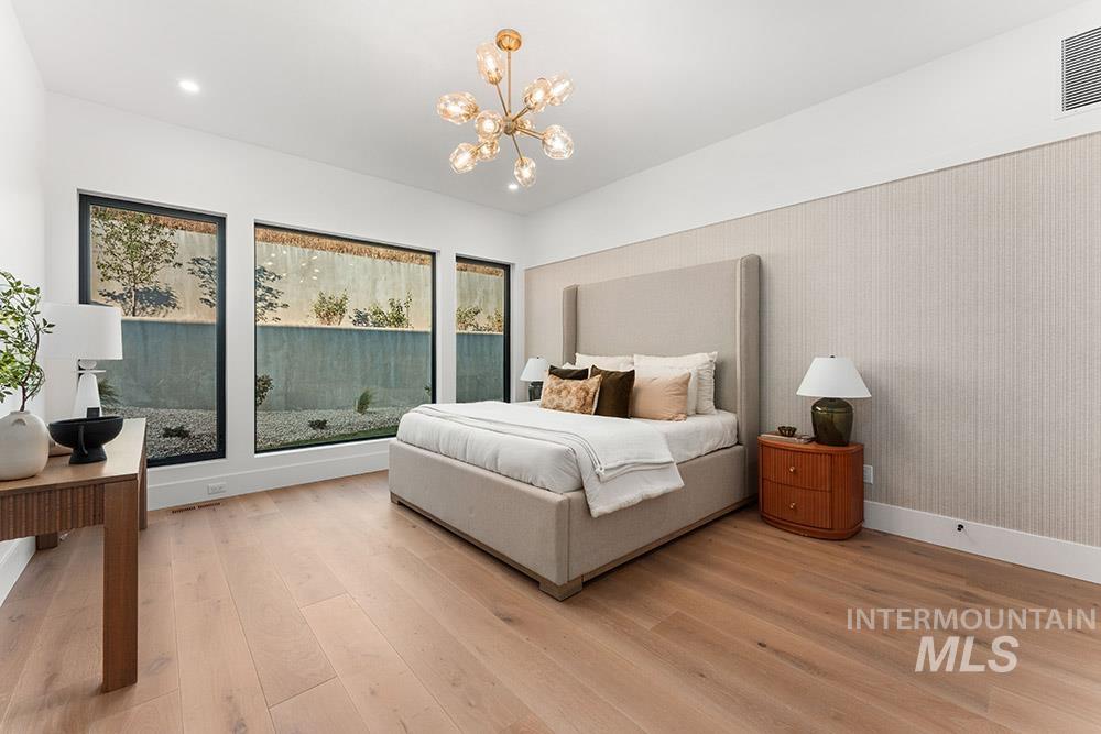 Bedroom with light wood-type flooring, a chandelier, and recessed lighting