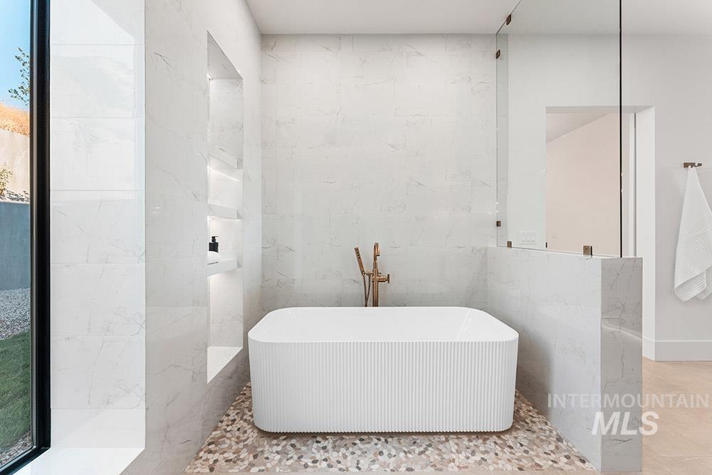 Full bathroom featuring tile walls and a freestanding bath
