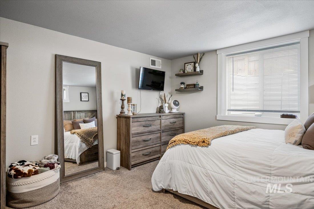 Bedroom featuring light carpet