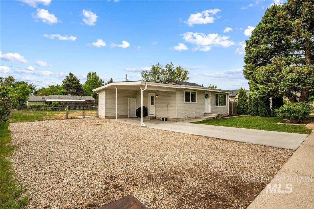 View of front facade featuring concrete driveway and a carport