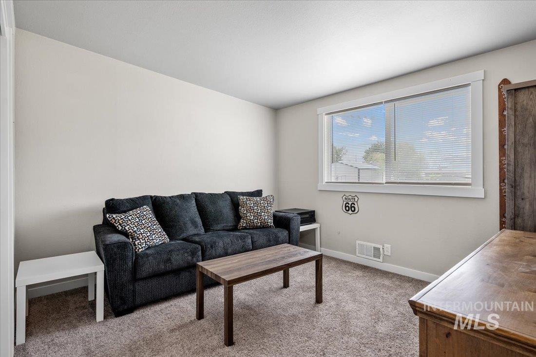 Carpeted living room featuring baseboards