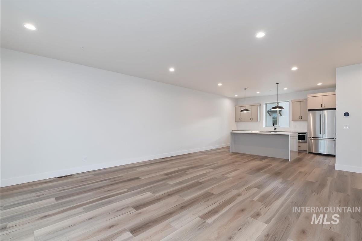 Unfurnished living room with recessed lighting and light wood-type flooring