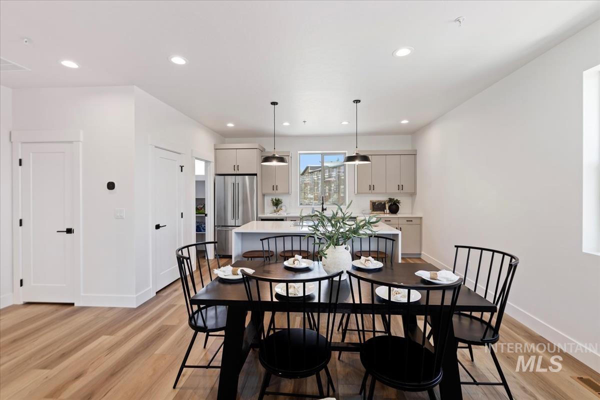 Dining area with light wood-style floors and recessed lighting