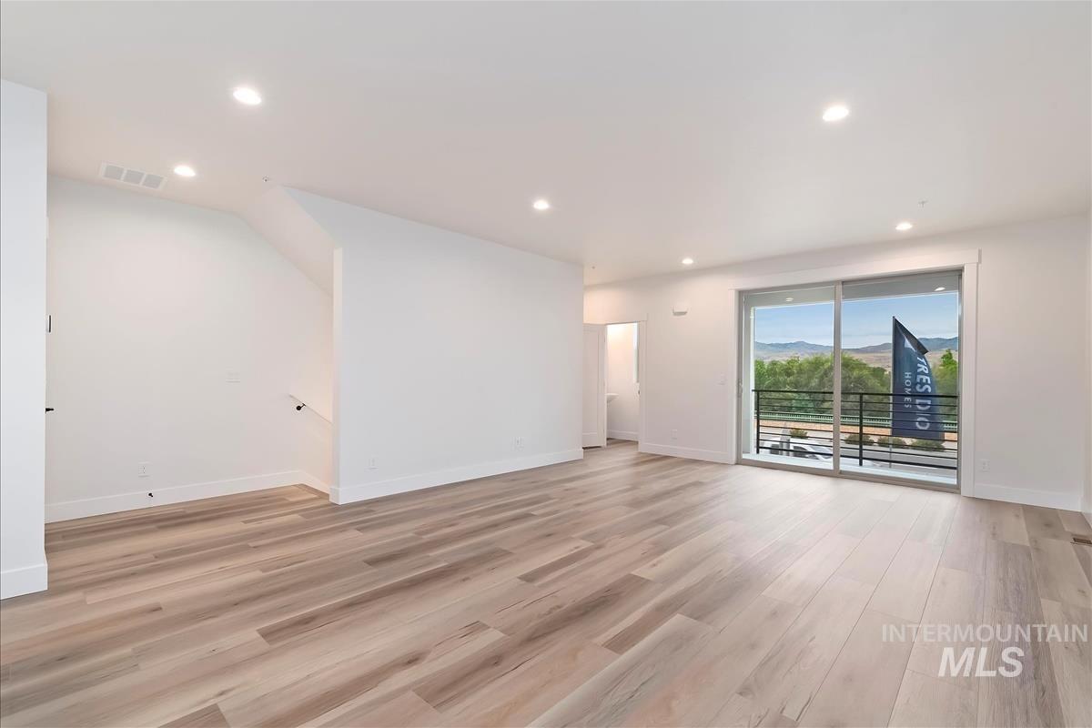 Unfurnished living room with recessed lighting, light wood-type flooring, and a mountain view