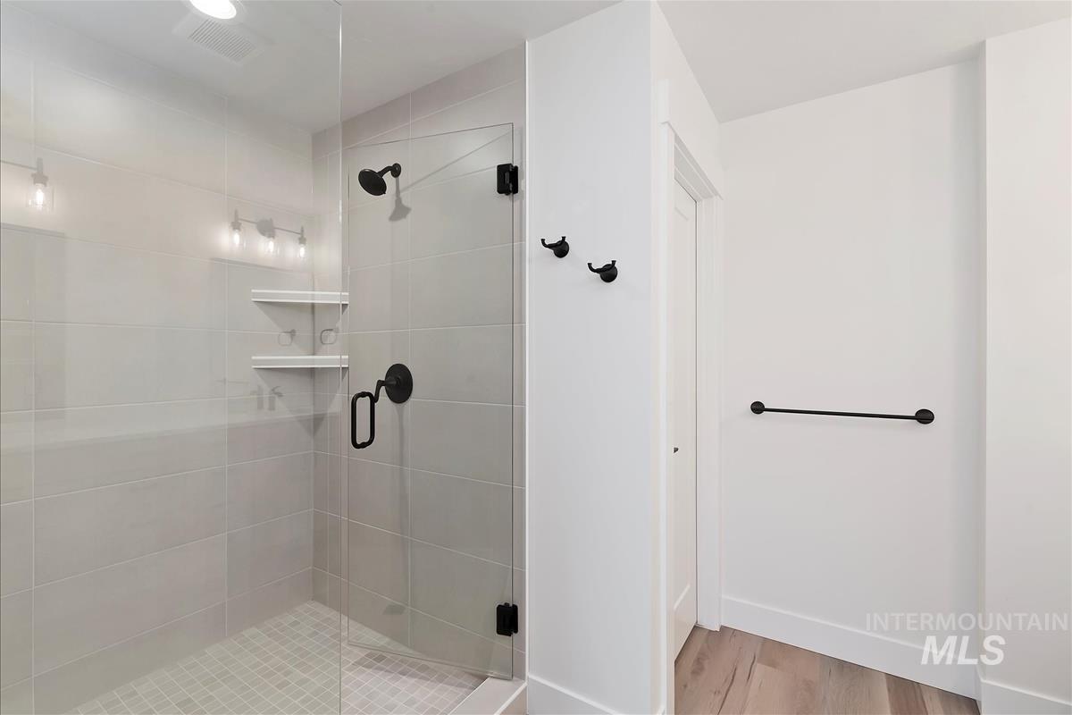 Bathroom featuring a stall shower and light wood-type flooring