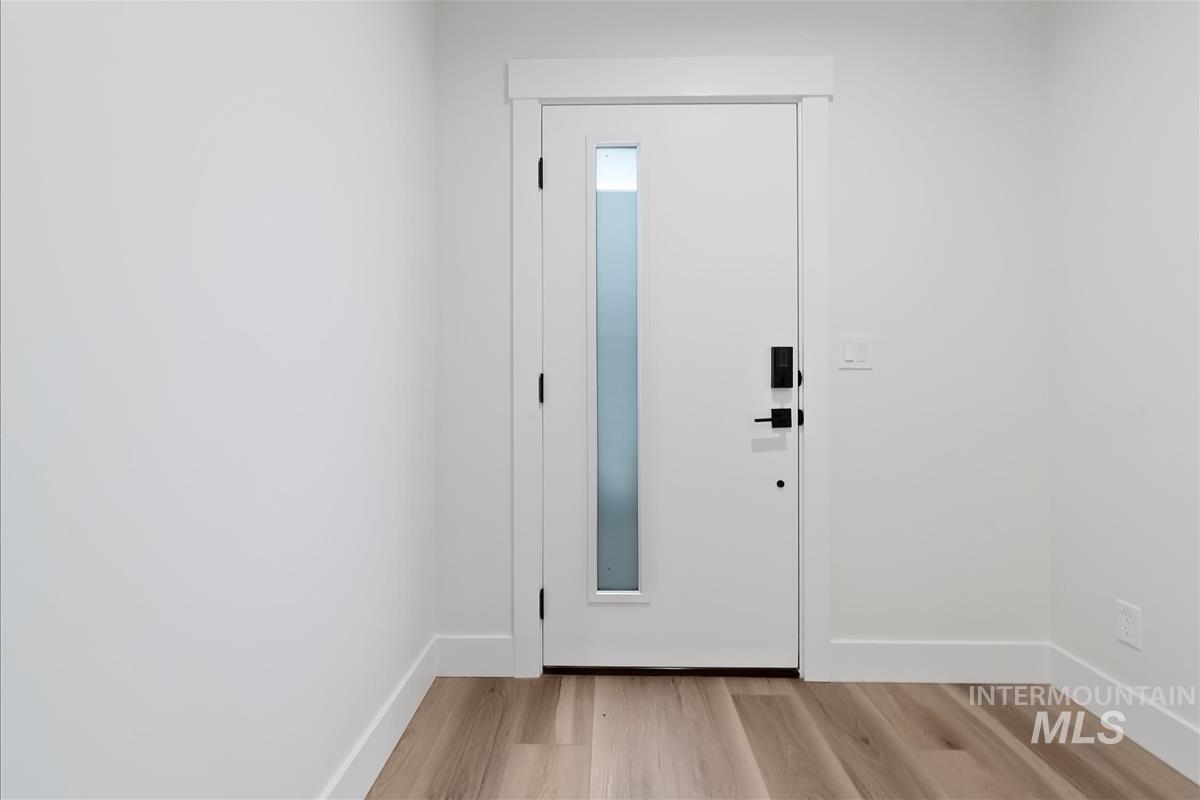 Foyer with light wood finished floors and baseboards