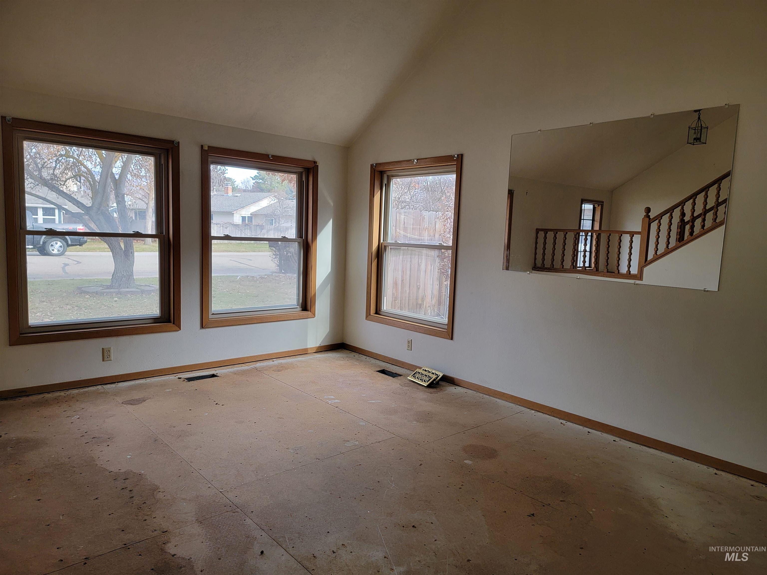 Unfurnished room with baseboards and vaulted ceiling