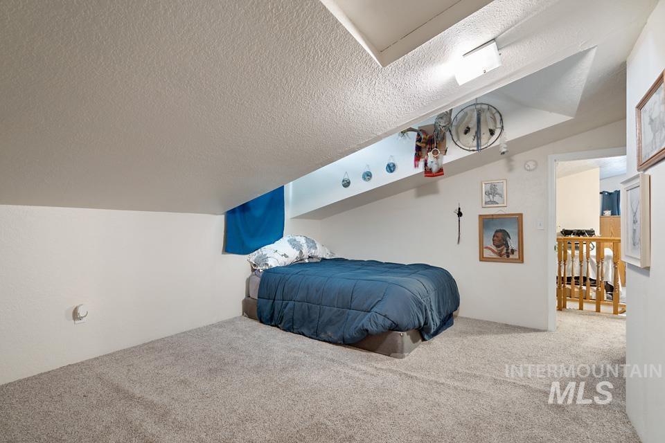Carpeted bedroom with a textured ceiling