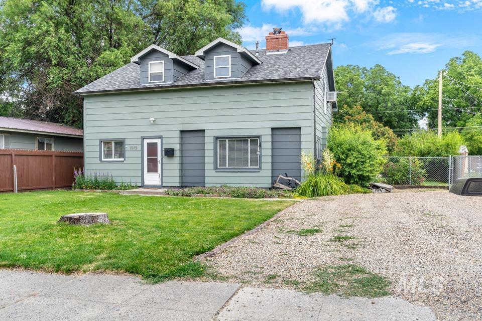 View of front of property with a chimney and a shingled roof