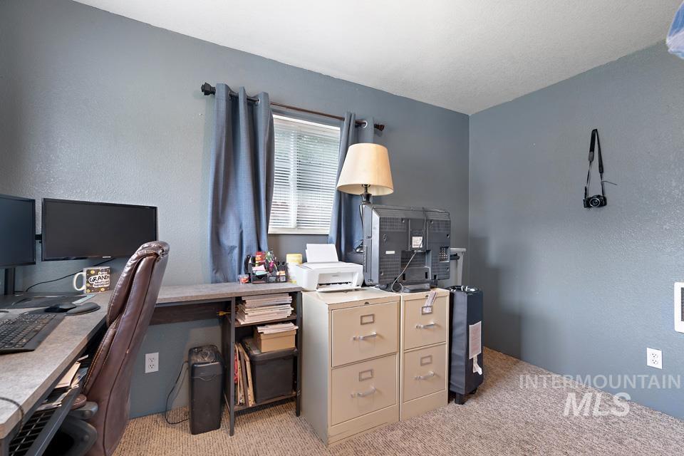 Office with light colored carpet and a textured wall