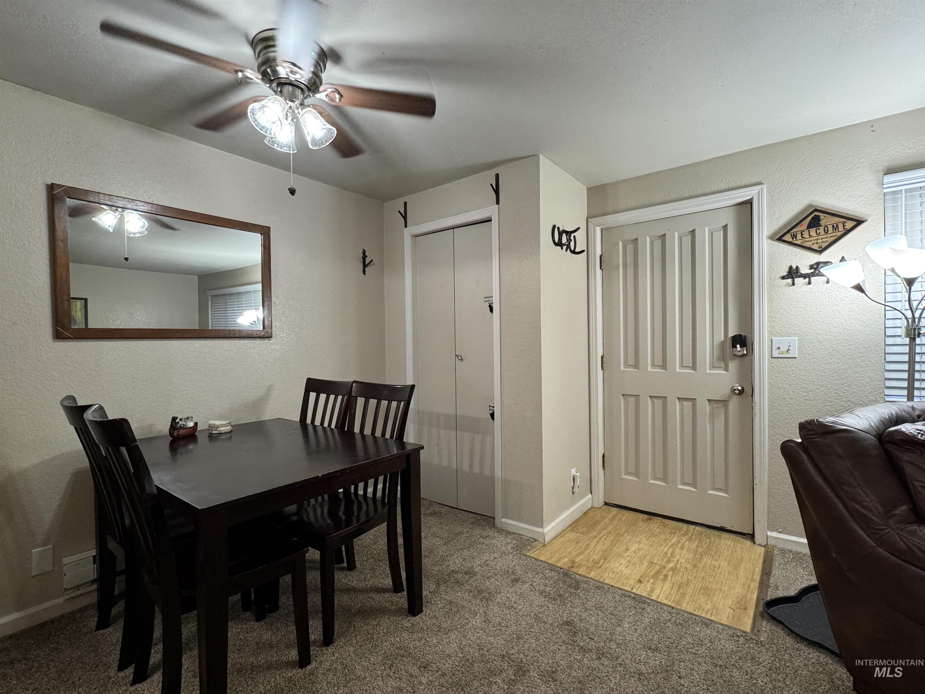 Carpeted dining area featuring a textured wall