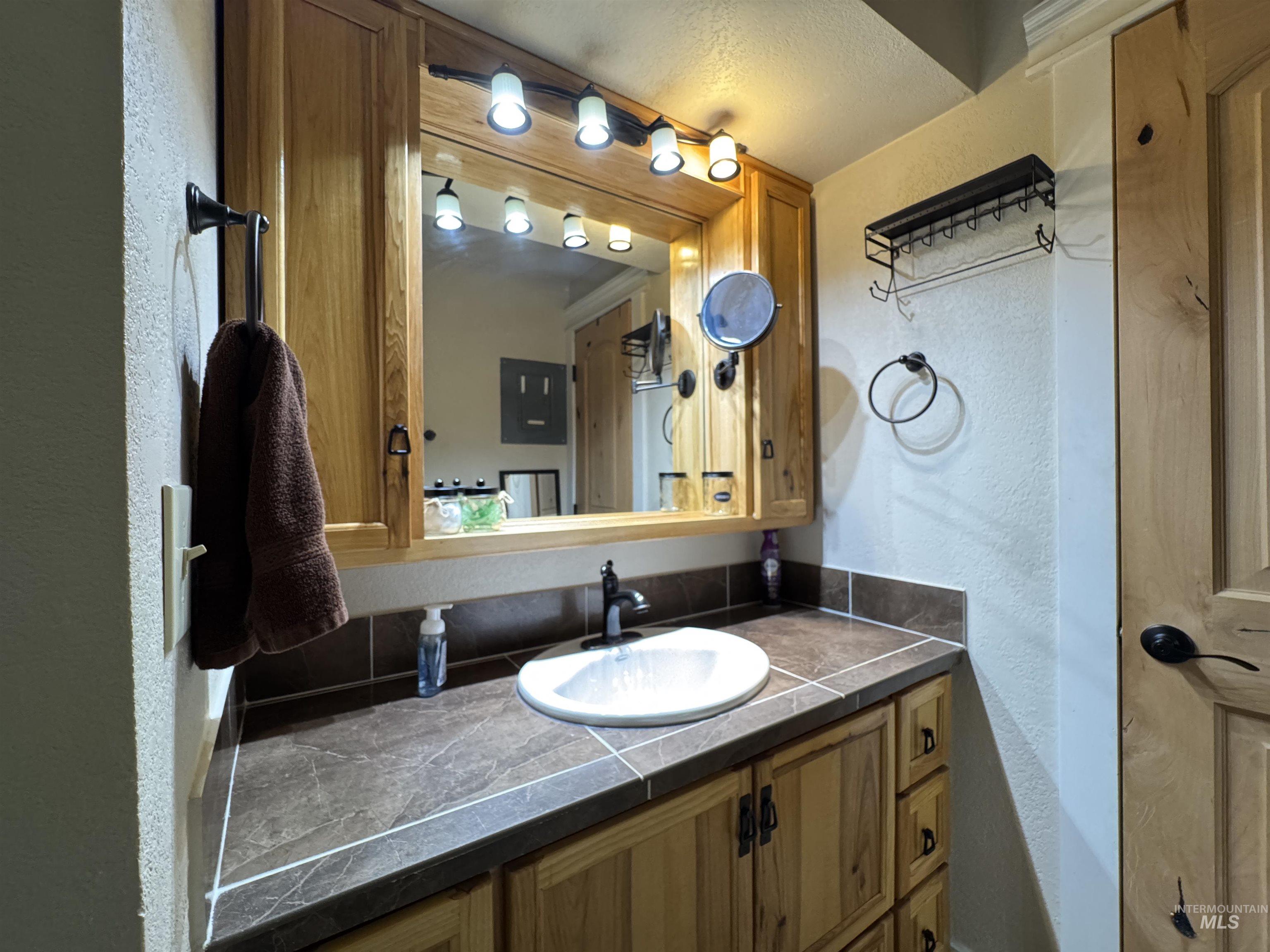 Bathroom featuring a textured wall and vanity