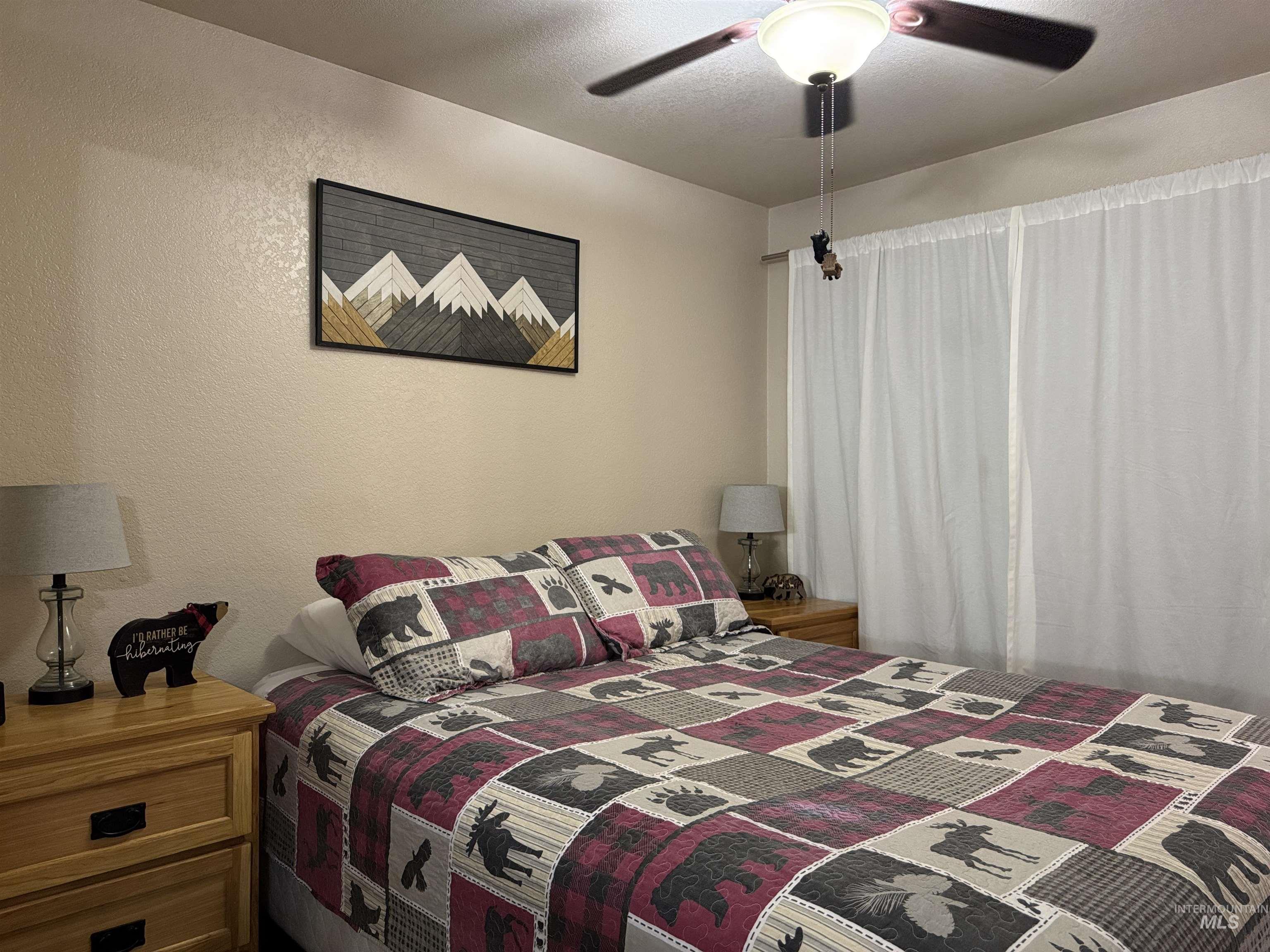 Bedroom with a textured wall and a ceiling fan