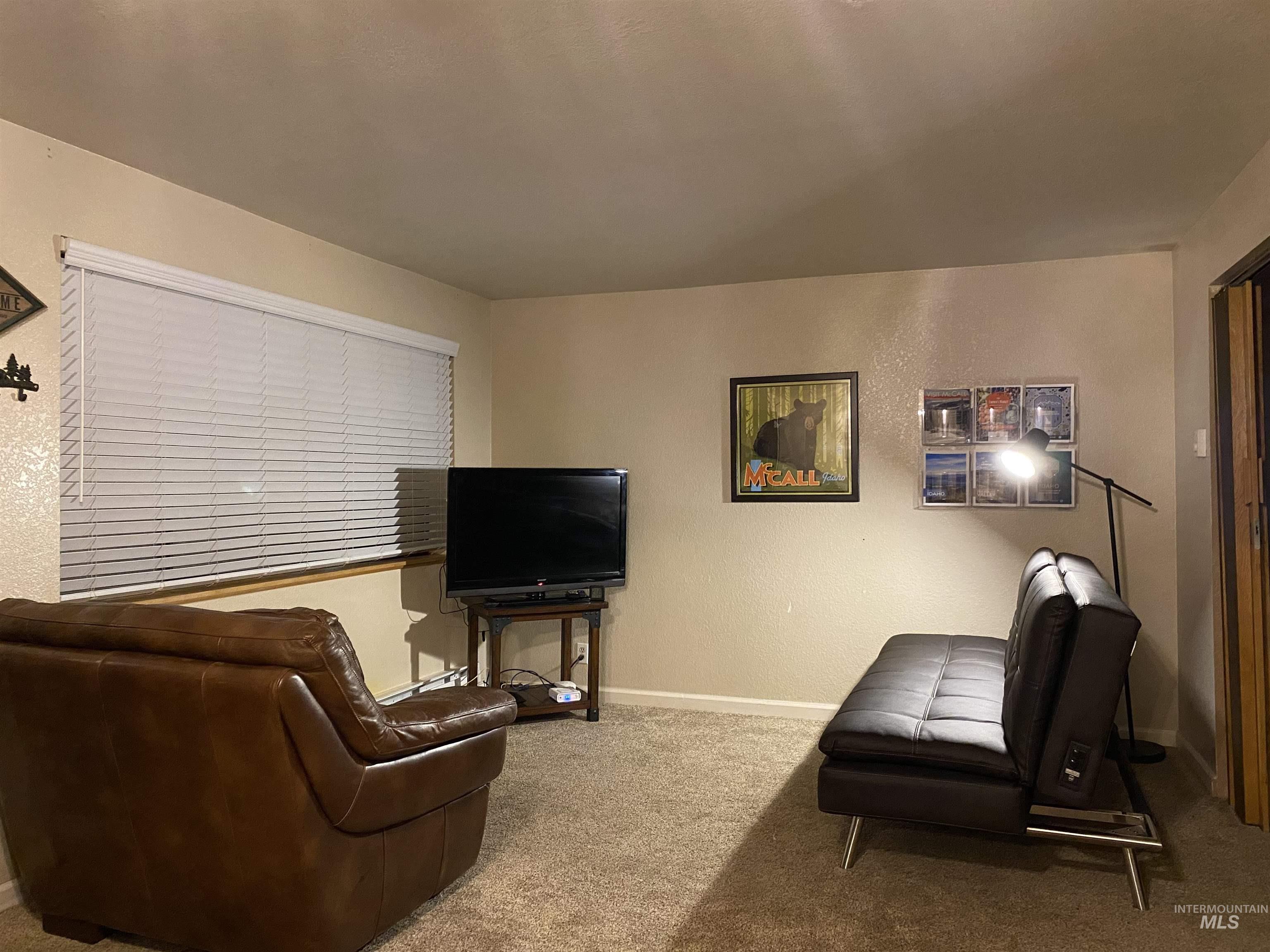 Living room with carpet flooring and a textured wall