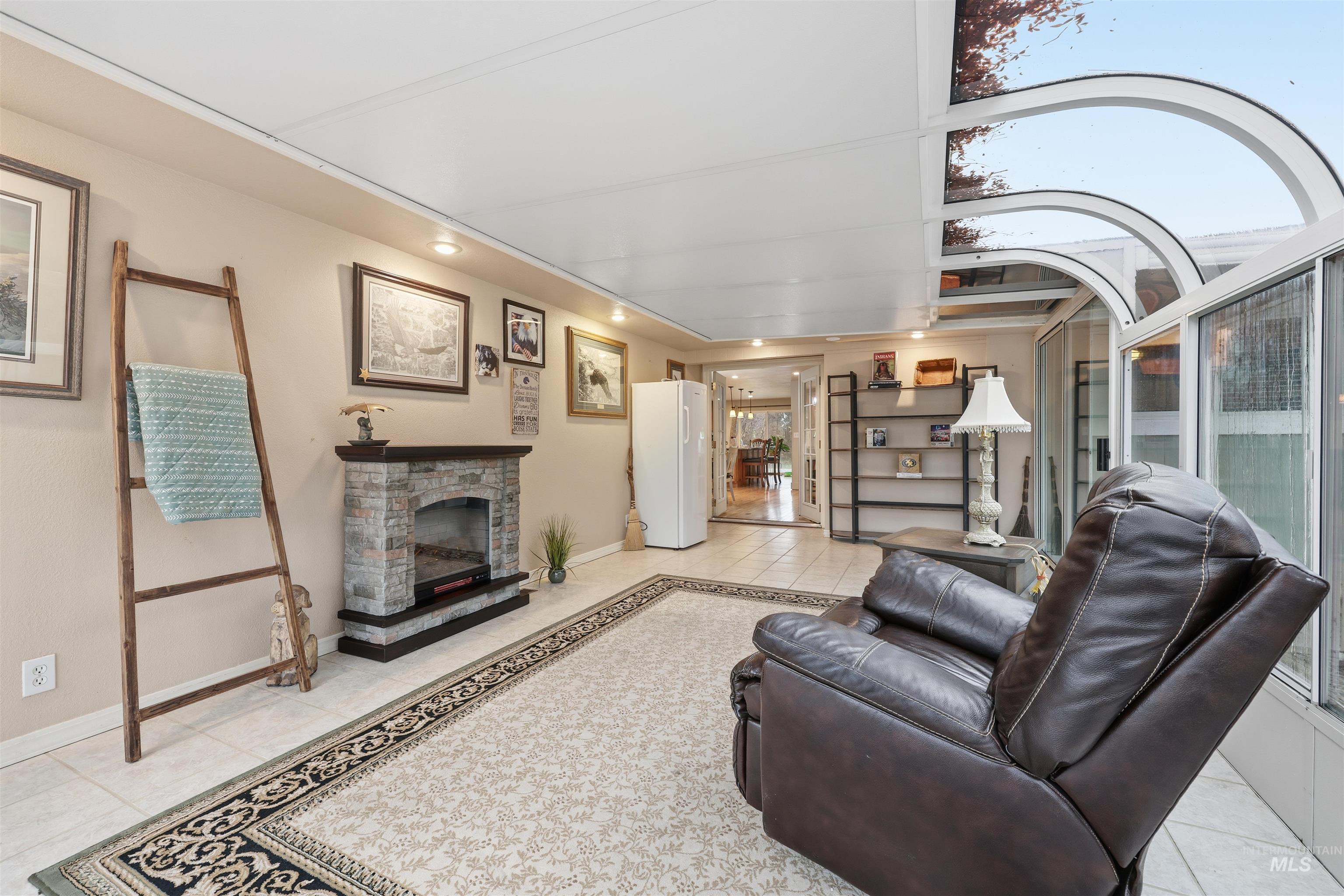 Sunroom featuring light tile patterned floors and an electric fireplace