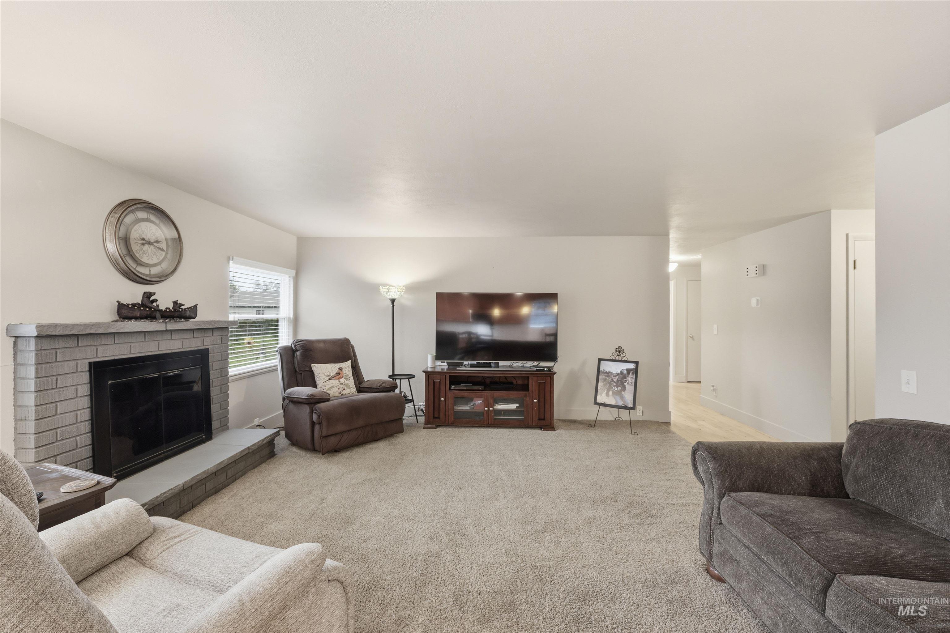 Living area featuring a fireplace and light colored carpet