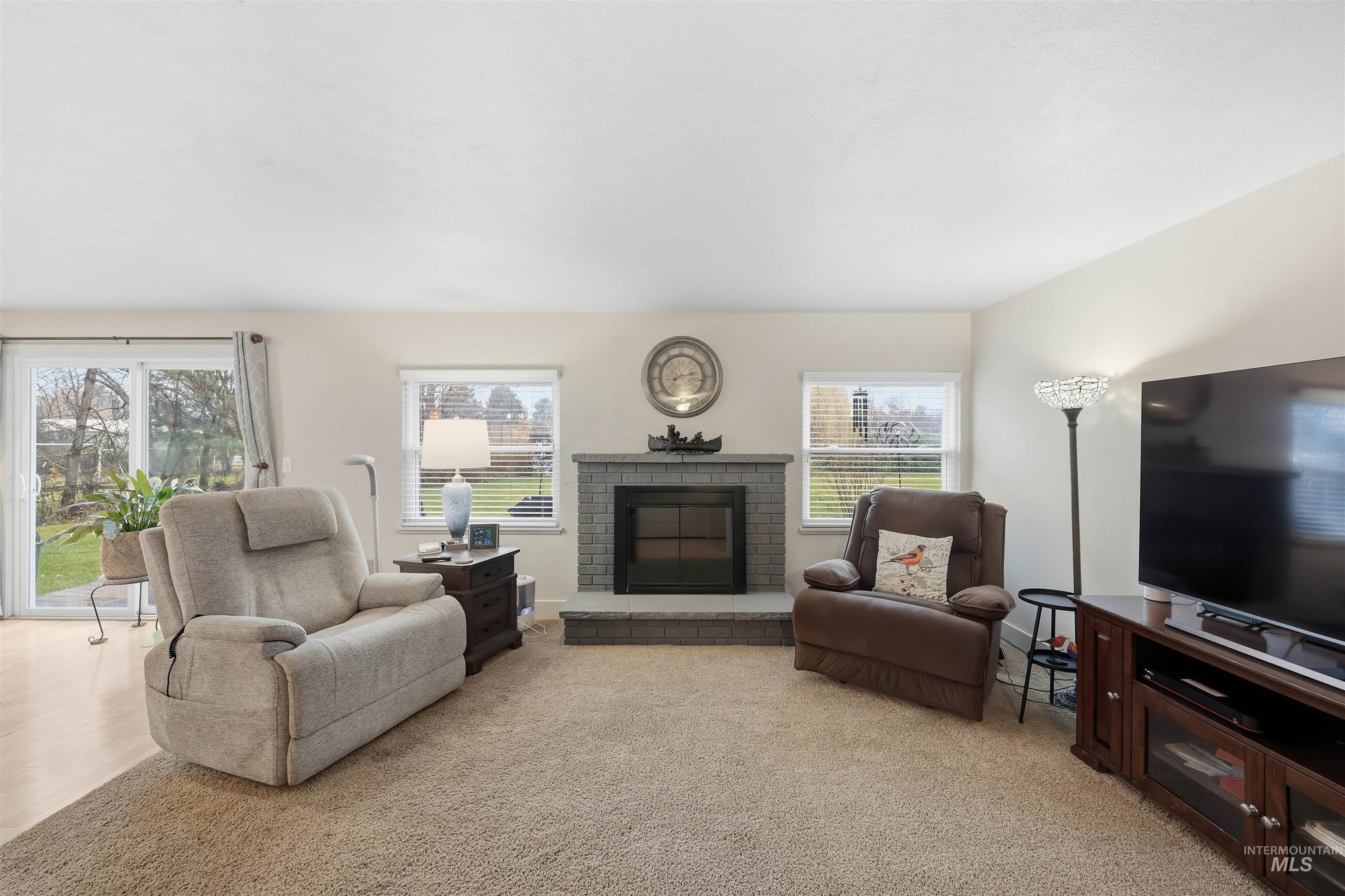 Living room featuring a fireplace and light carpet