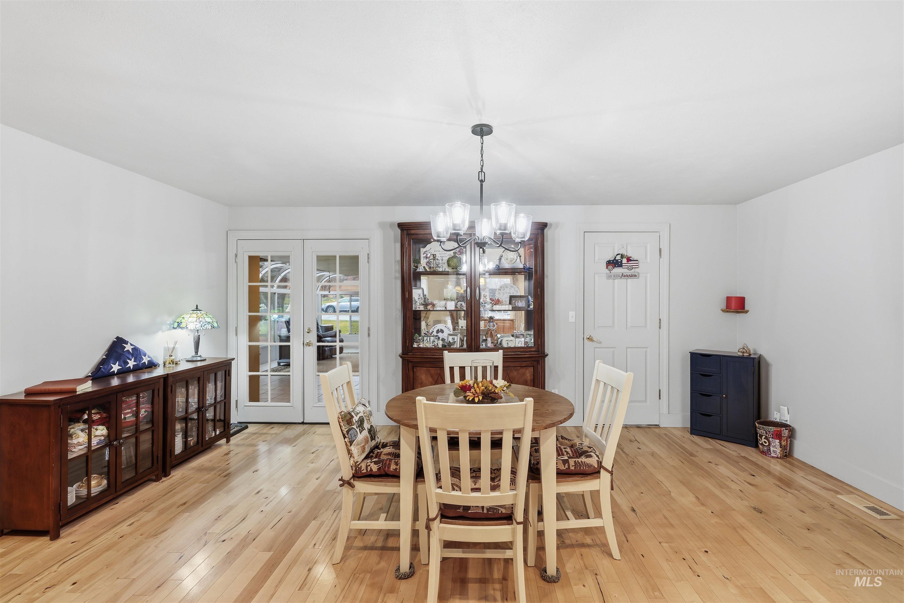 Dining space featuring a chandelier, french doors, and light wood finished floors