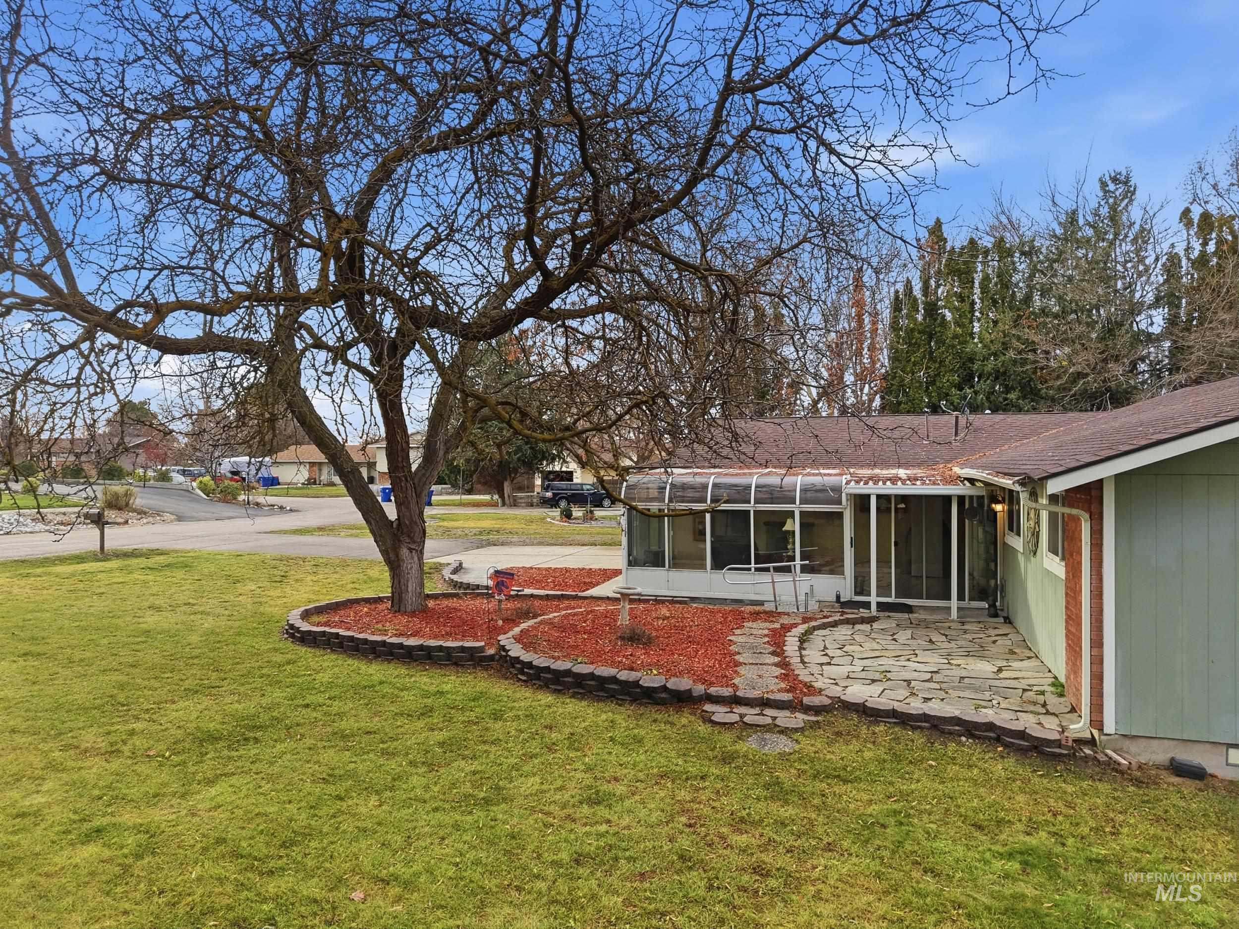 View of green lawn featuring a sunroom