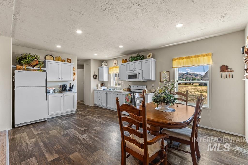 Dining room with recessed lighting, dark wood-style flooring, and a textured ceiling
