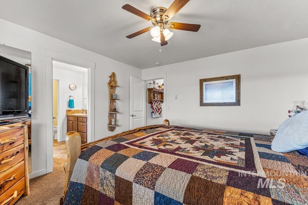 Bedroom featuring a ceiling fan and light colored carpet