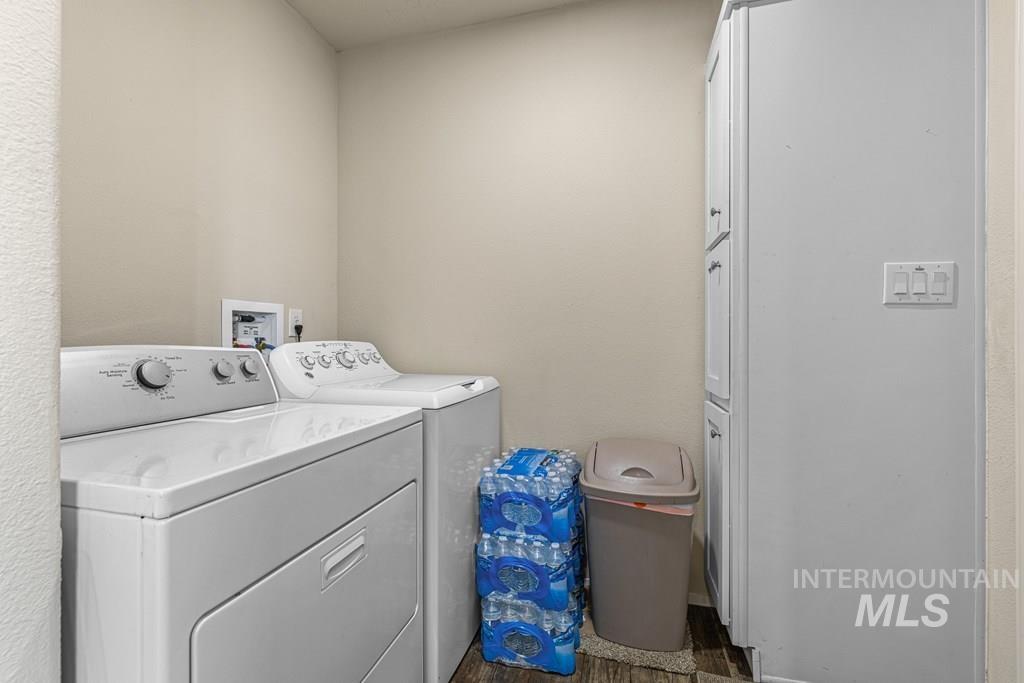 Laundry area with dark wood-type flooring and washing machine and dryer