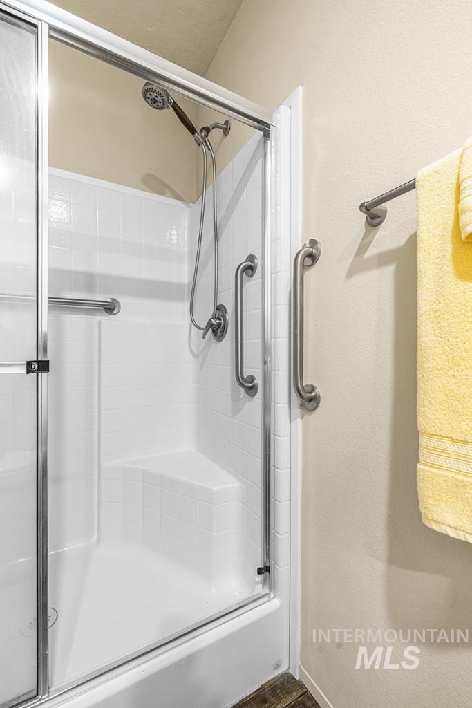 Bathroom featuring a stall shower and a textured wall