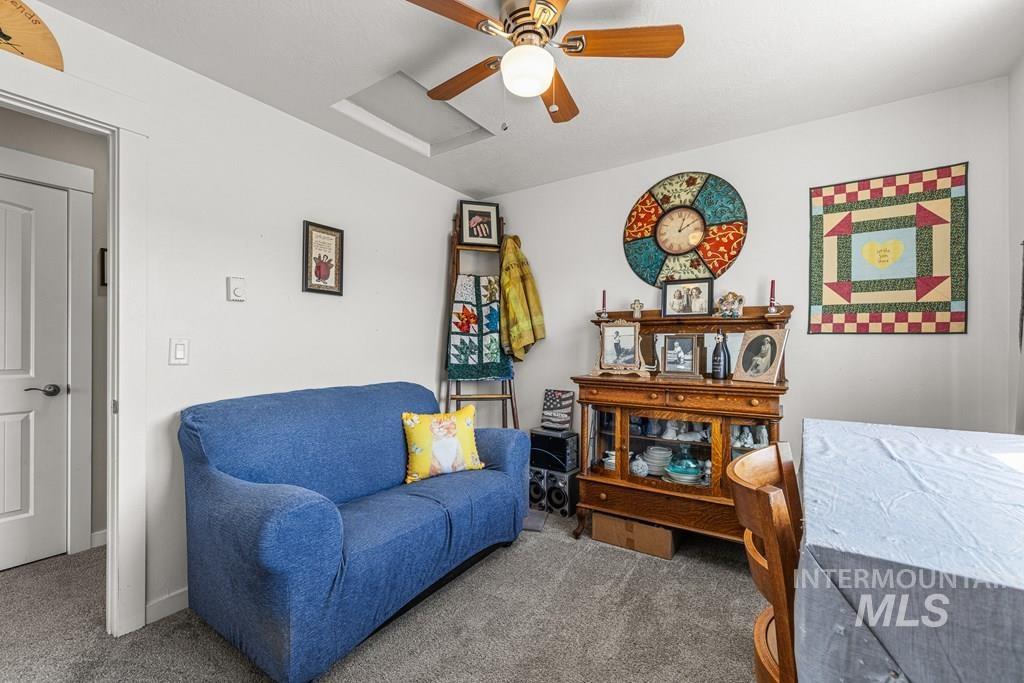 Sitting room featuring attic access, carpet, and a ceiling fan