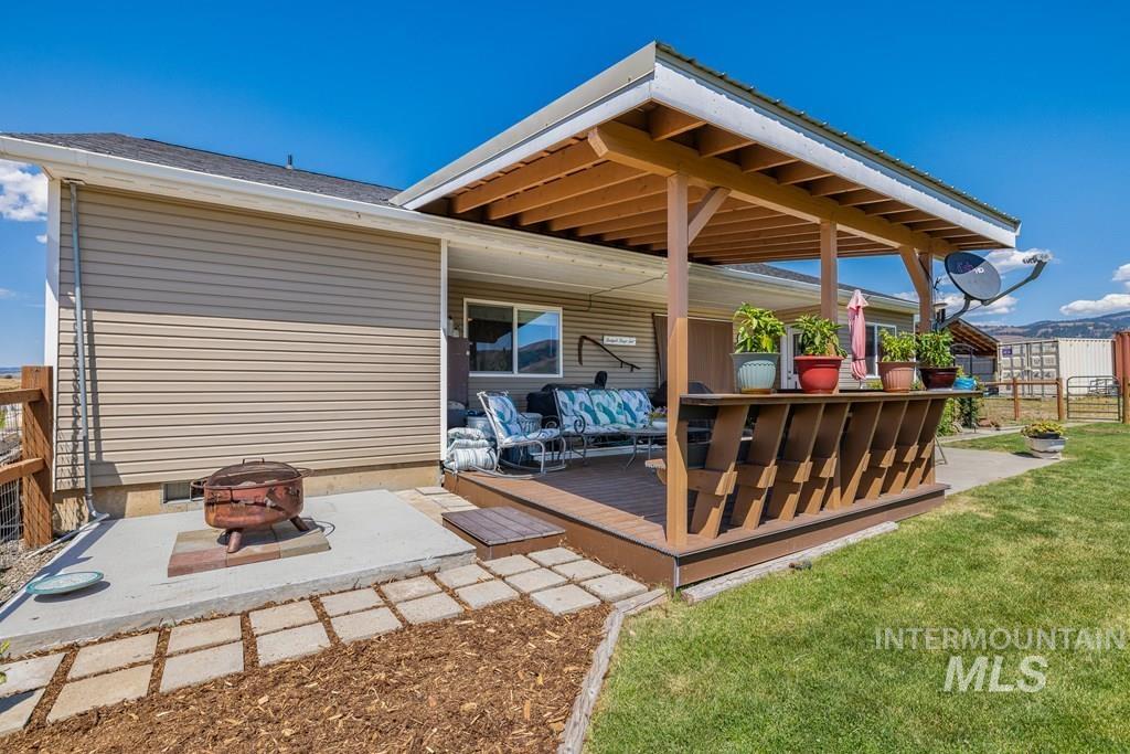 Wooden deck featuring a fire pit and a patio