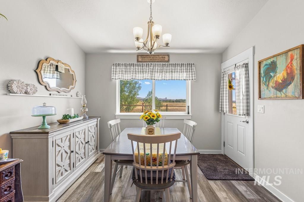 Dining area with wood finished floors and a chandelier