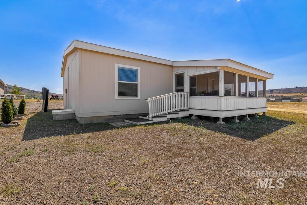 Rear view of property with crawl space, a sunroom, and a wooden deck