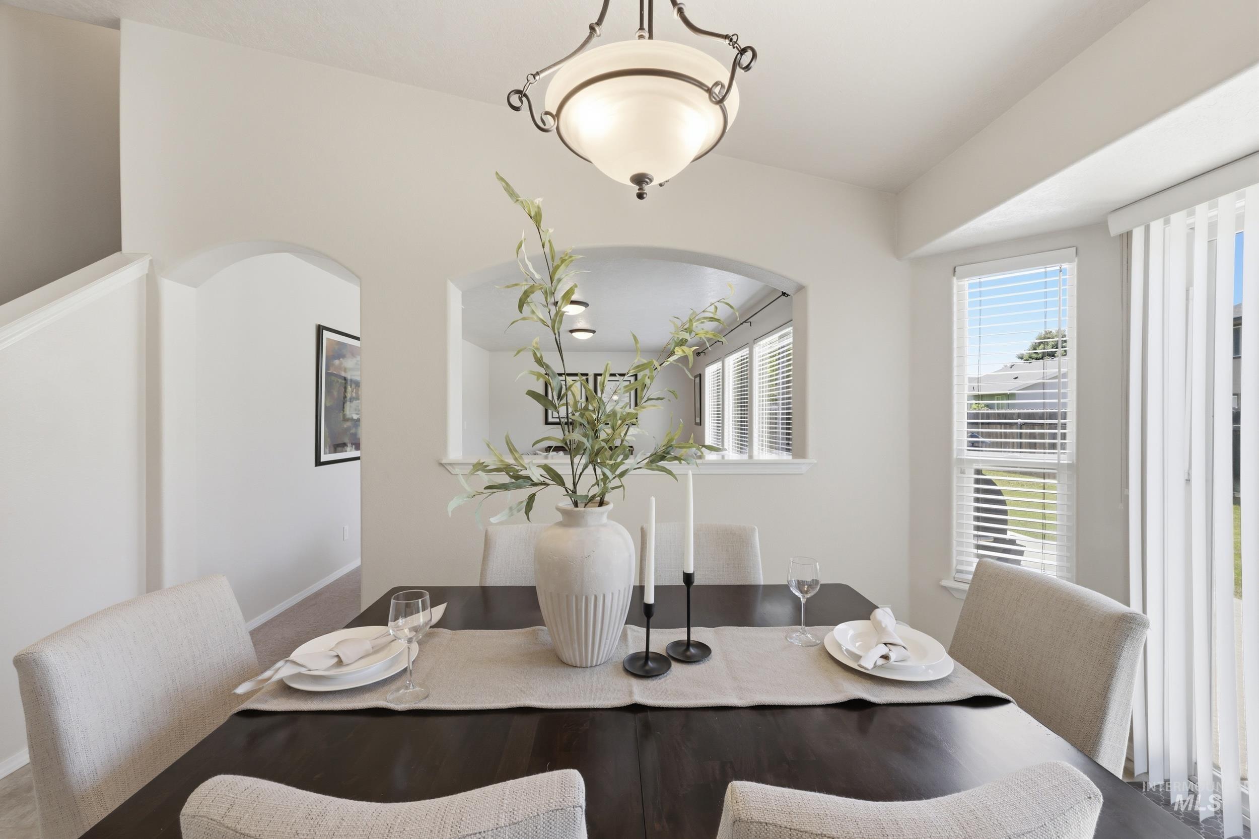 Dining space with a dark wood-finish table and upholstered chairs