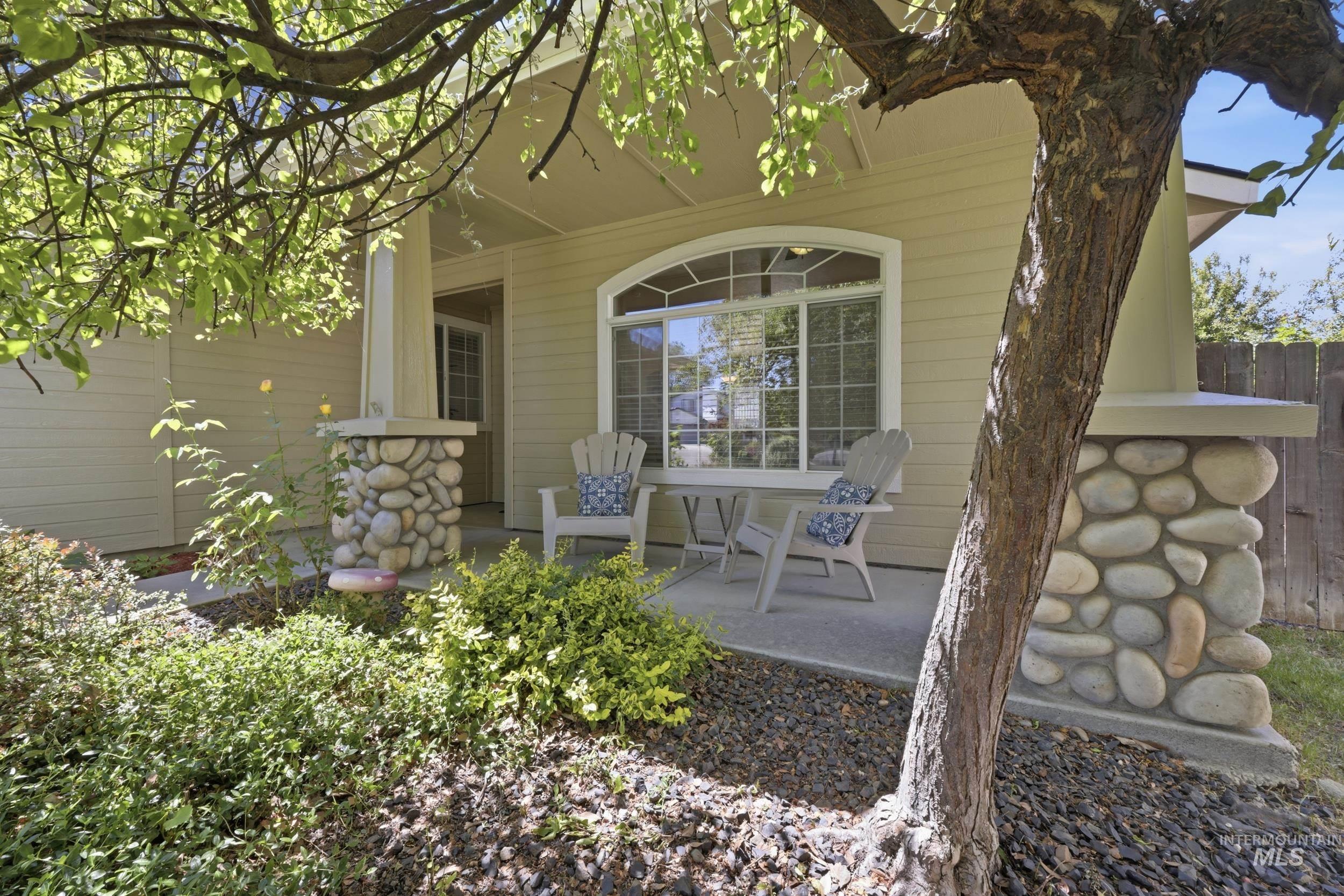 Inviting front porch featuring river rock column bases, a covered entry, and an arched transom window