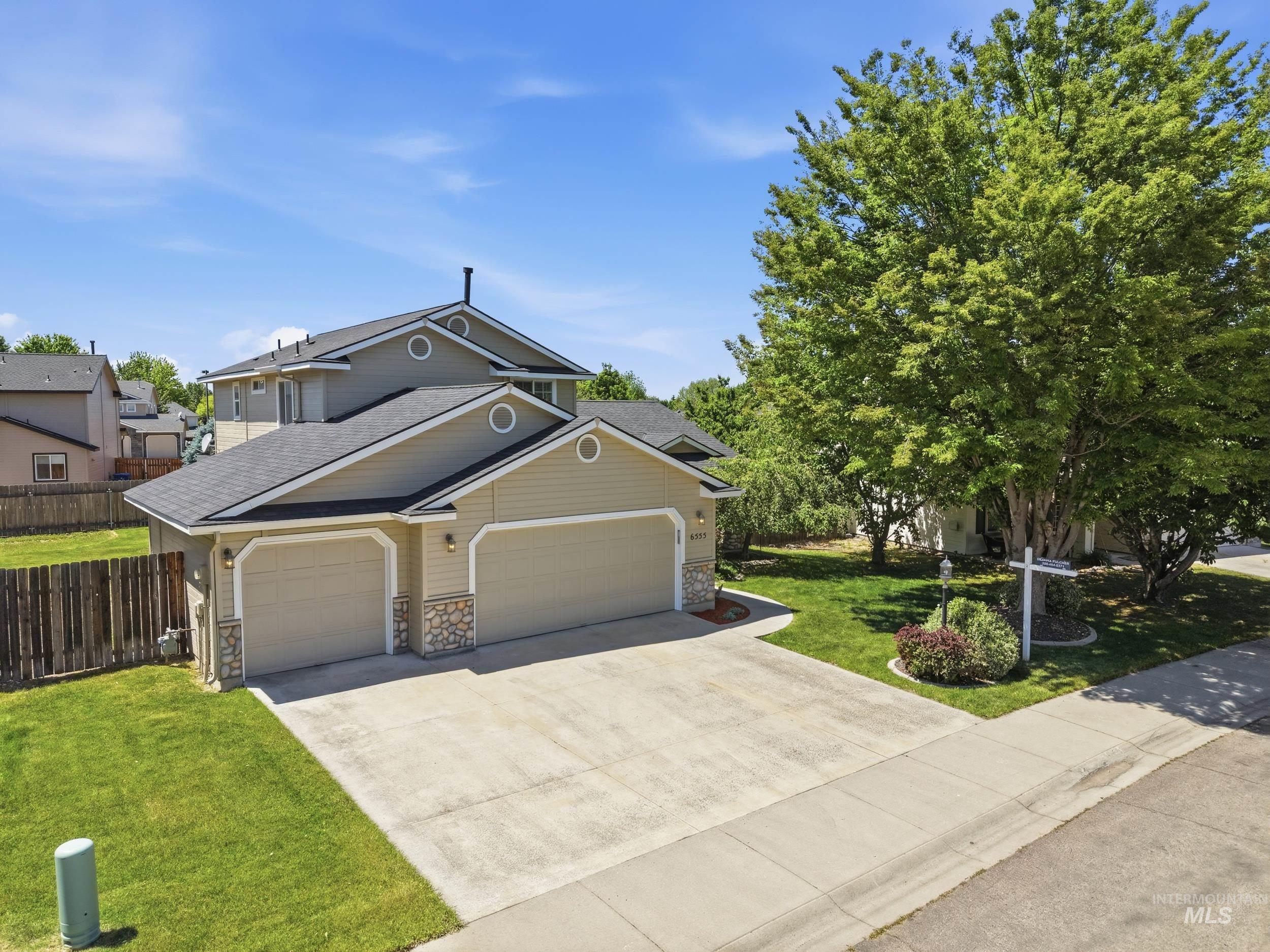 Contemporary two-story residence with a beige siding exterior and dark shingle roofing