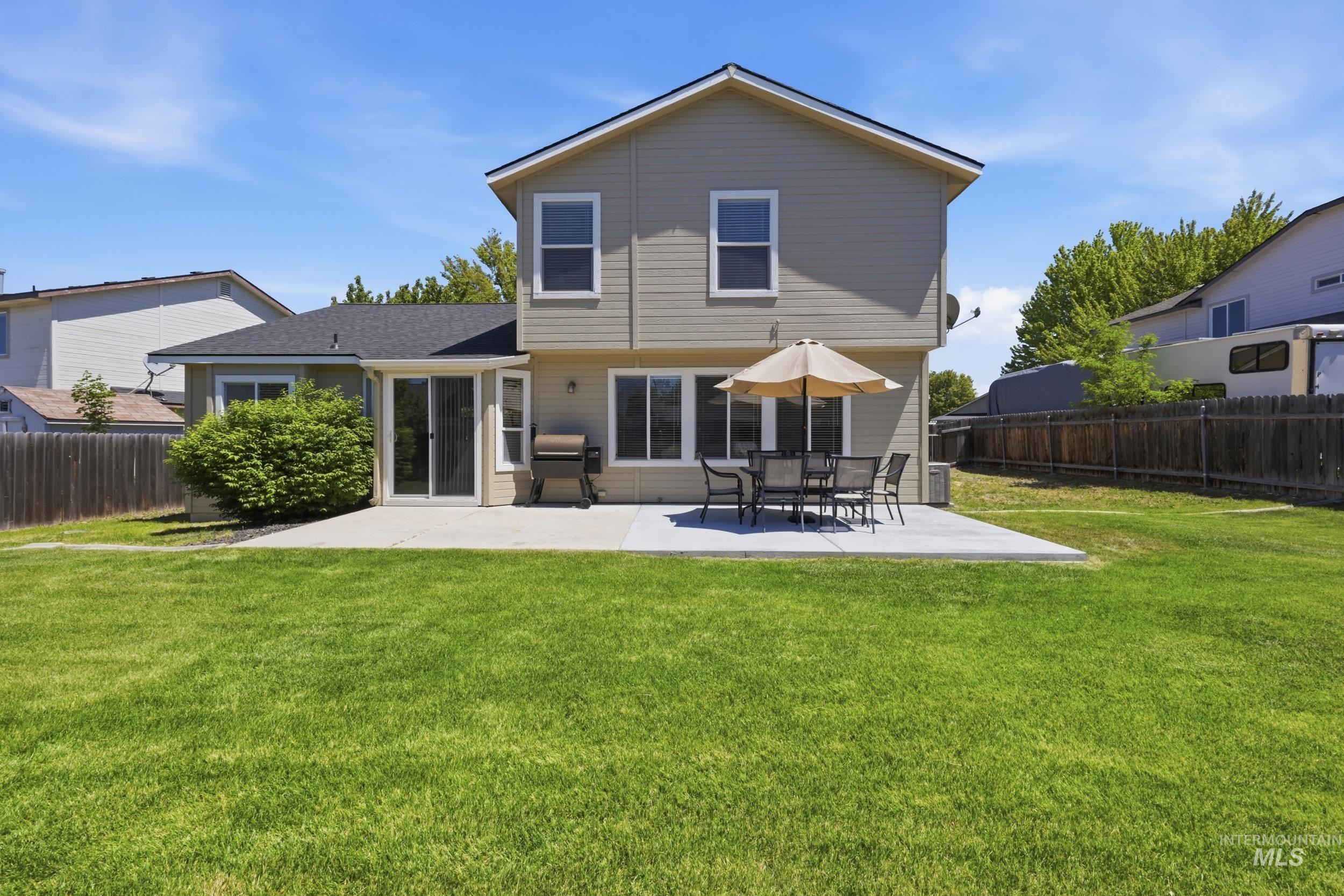 Expansive green lawn with a large concrete patio, providing significant outdoor space