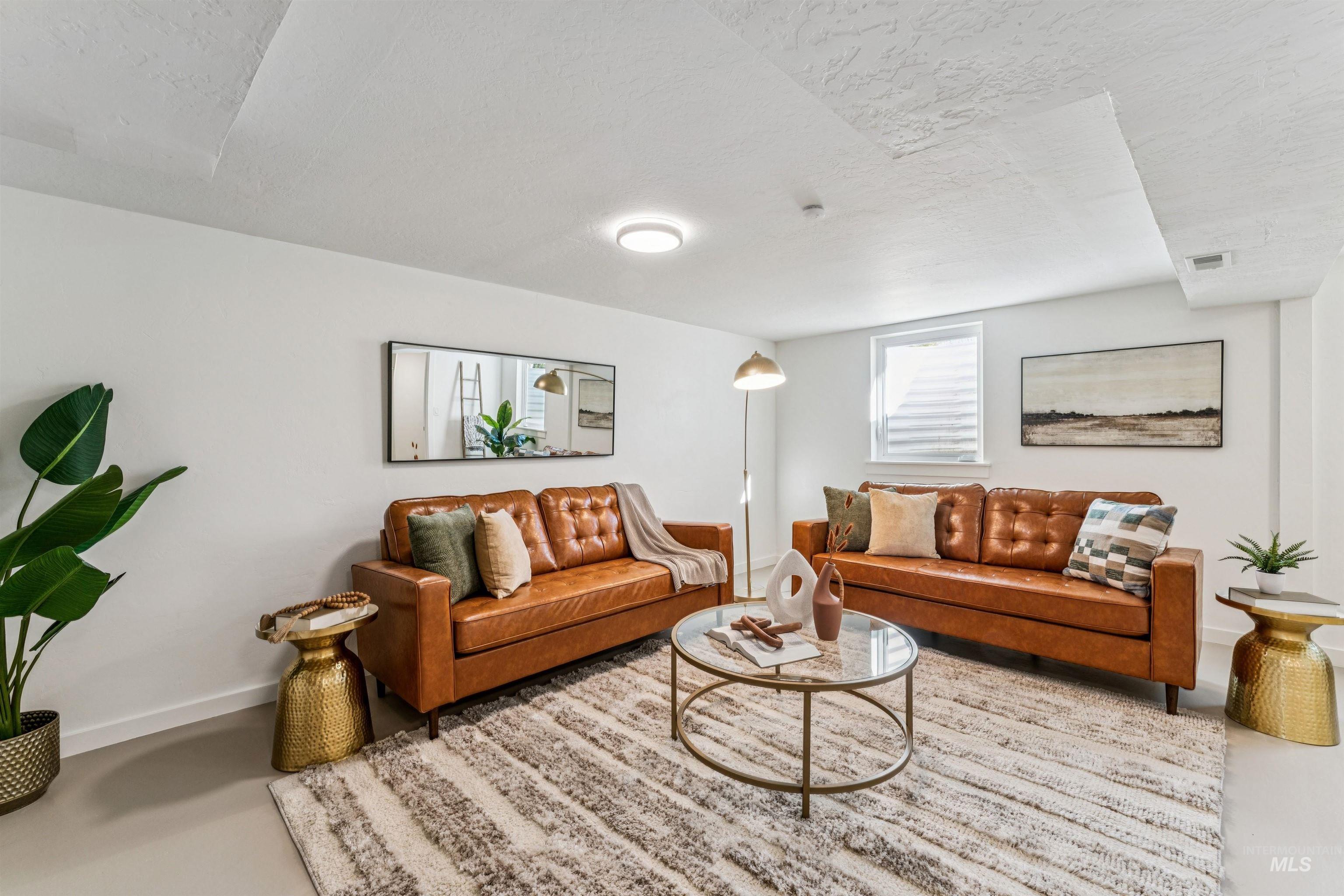 Living room area with a textured ceiling and concrete floors