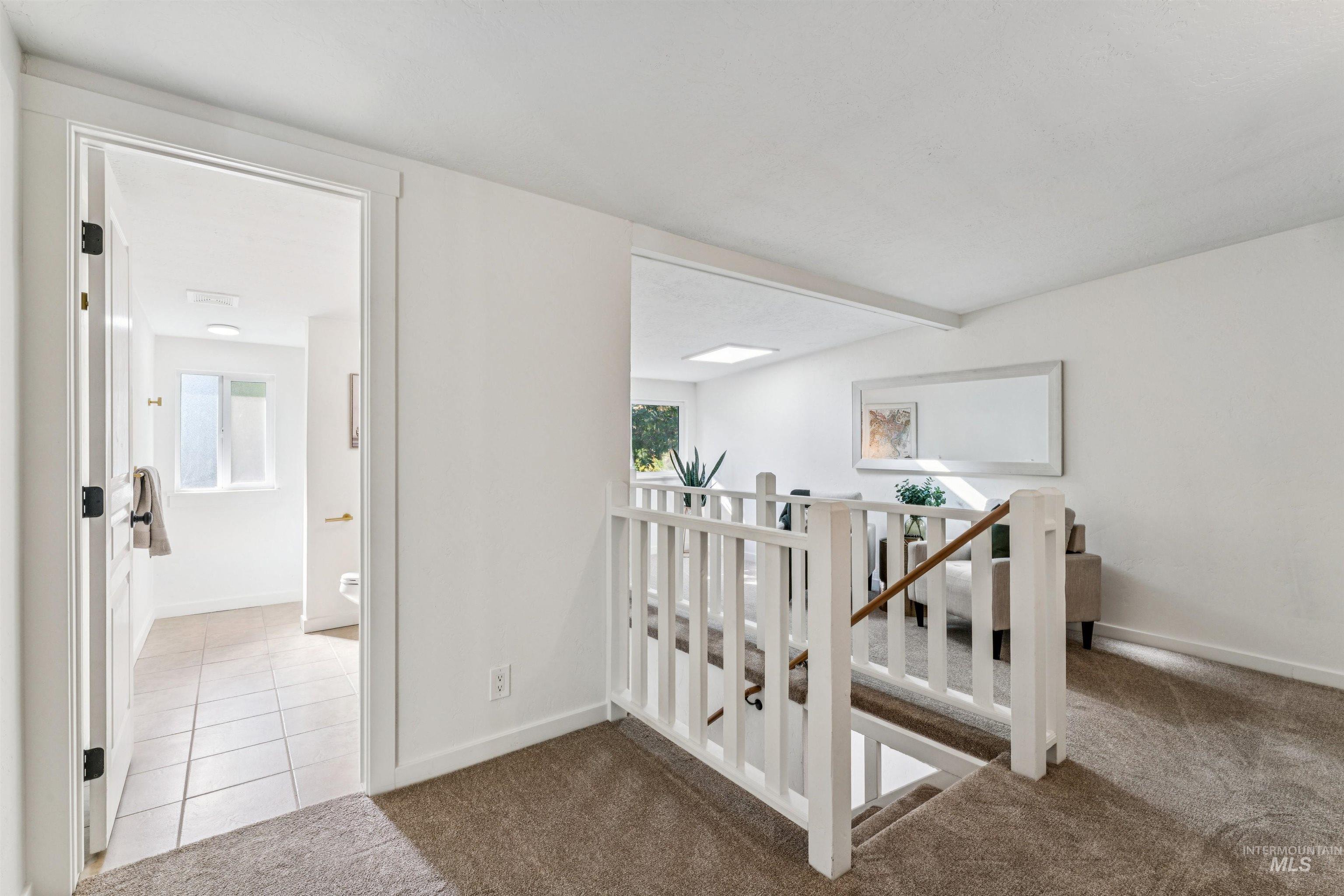 Loft featuring carpet, plenty of natural light, and tile patterned flooring