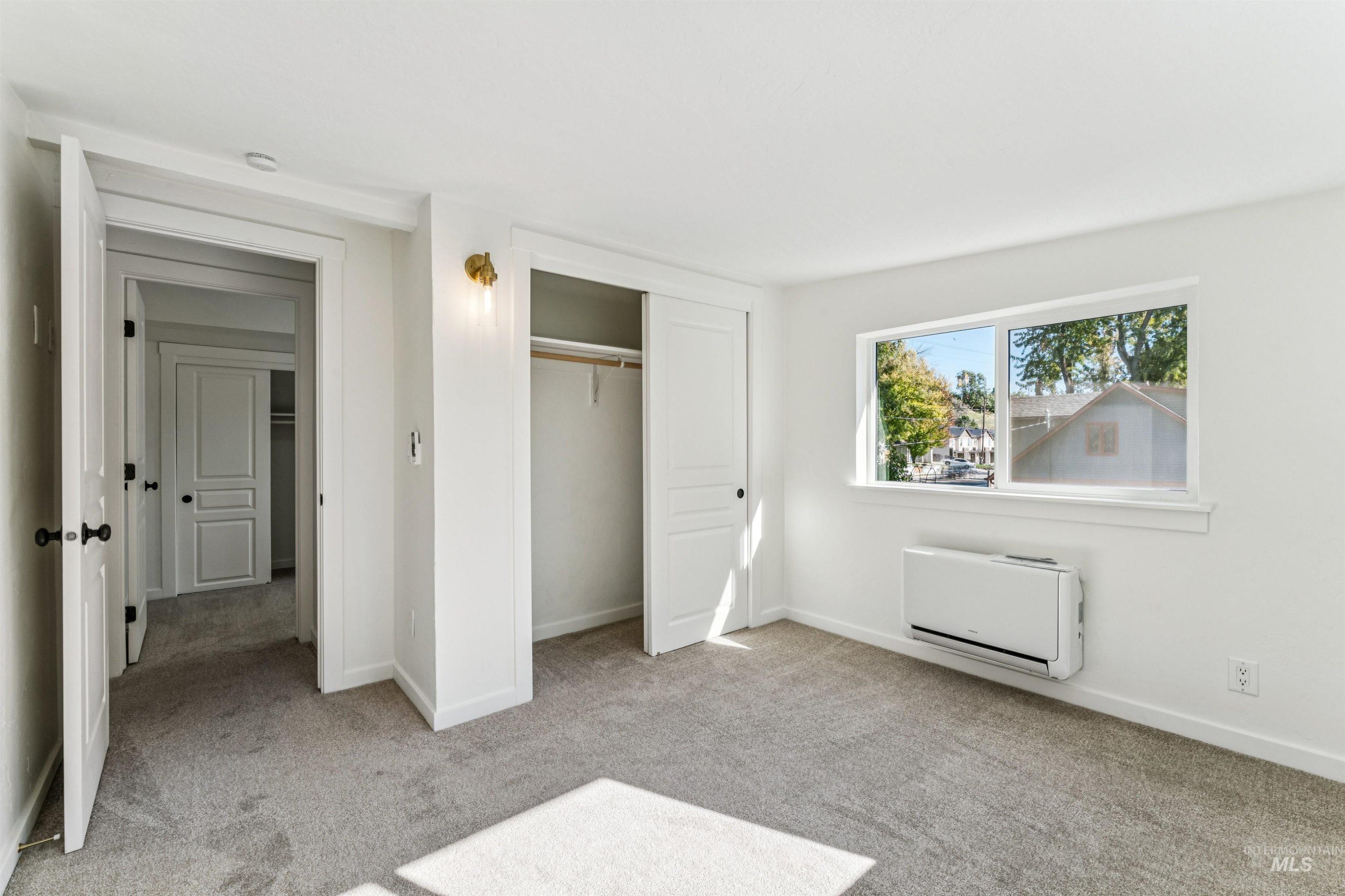 Unfurnished bedroom with light carpet and a closet