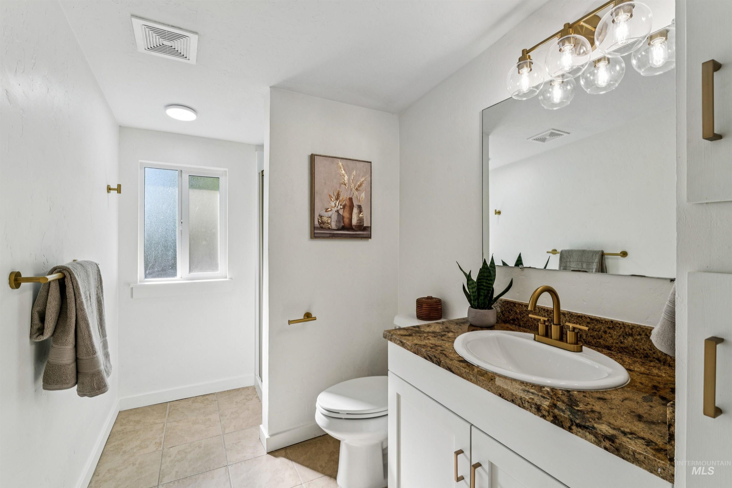 Bathroom with vanity, light tile patterned floors, and a stall shower