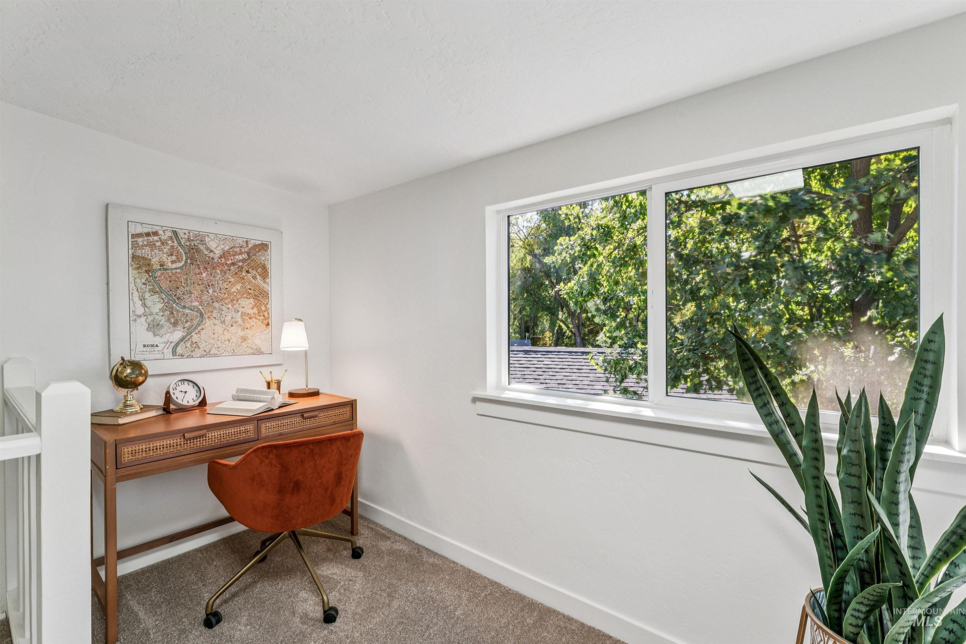 Carpeted office space featuring baseboards