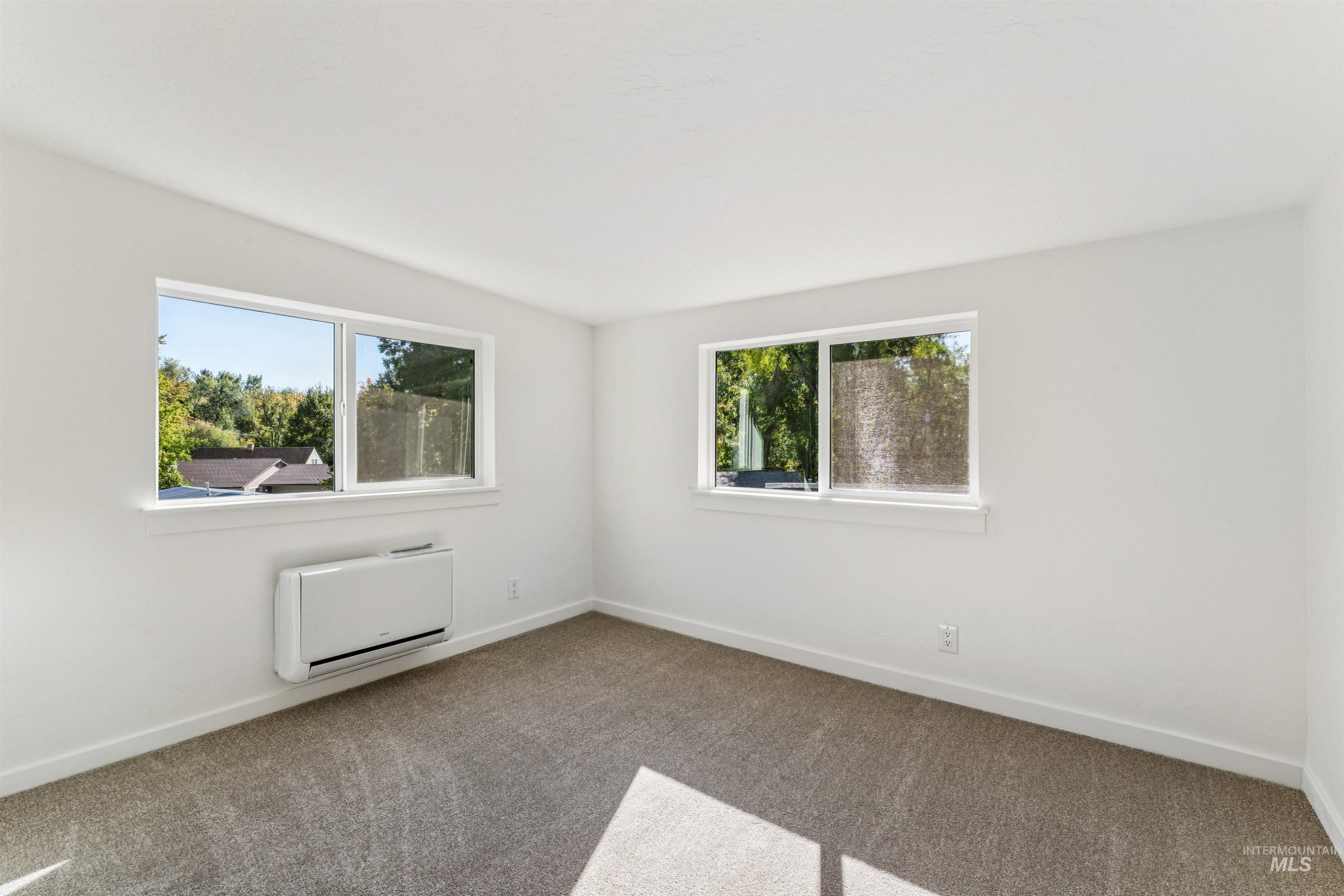Carpeted spare room featuring baseboards
