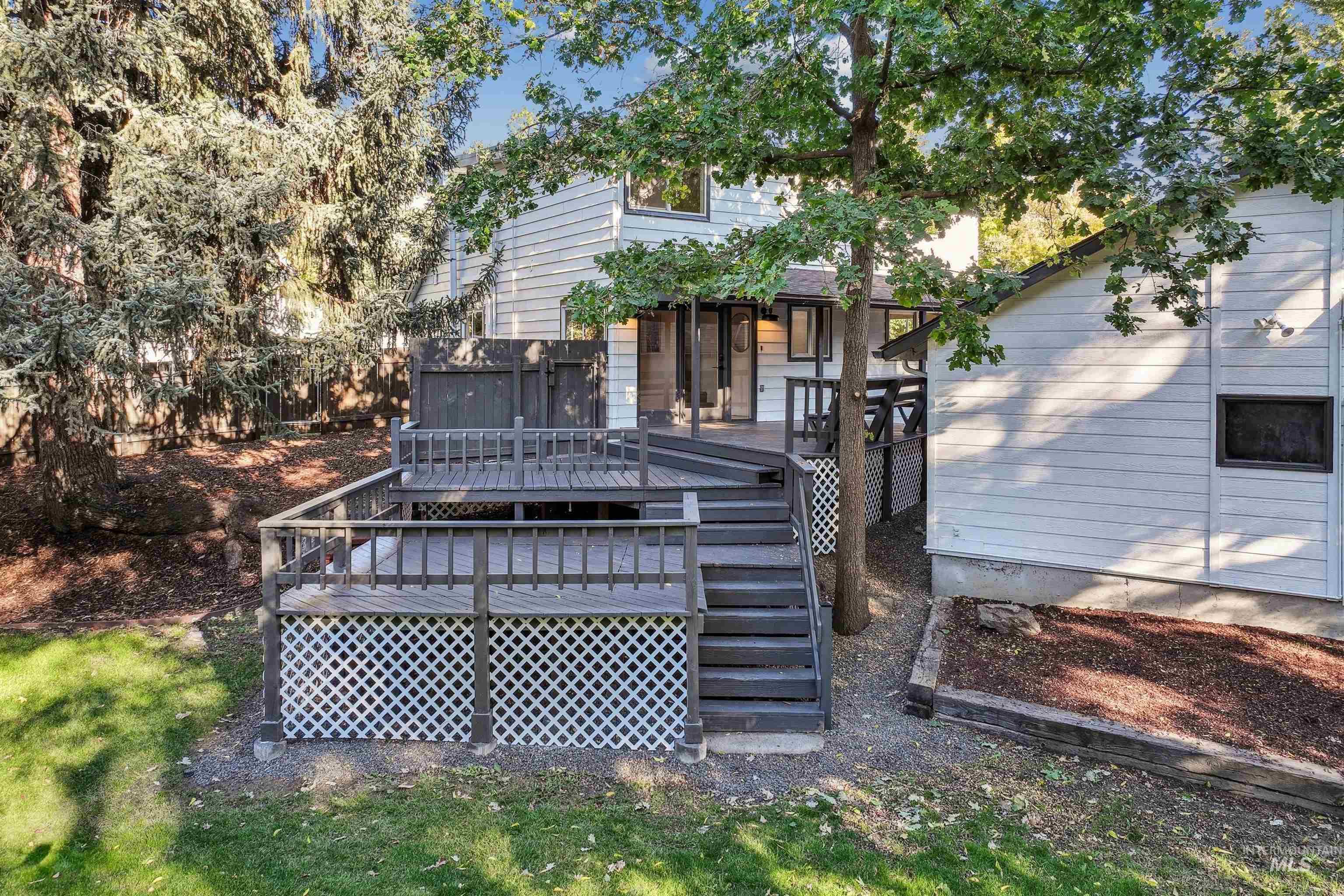 Back of property featuring a deck and stairs