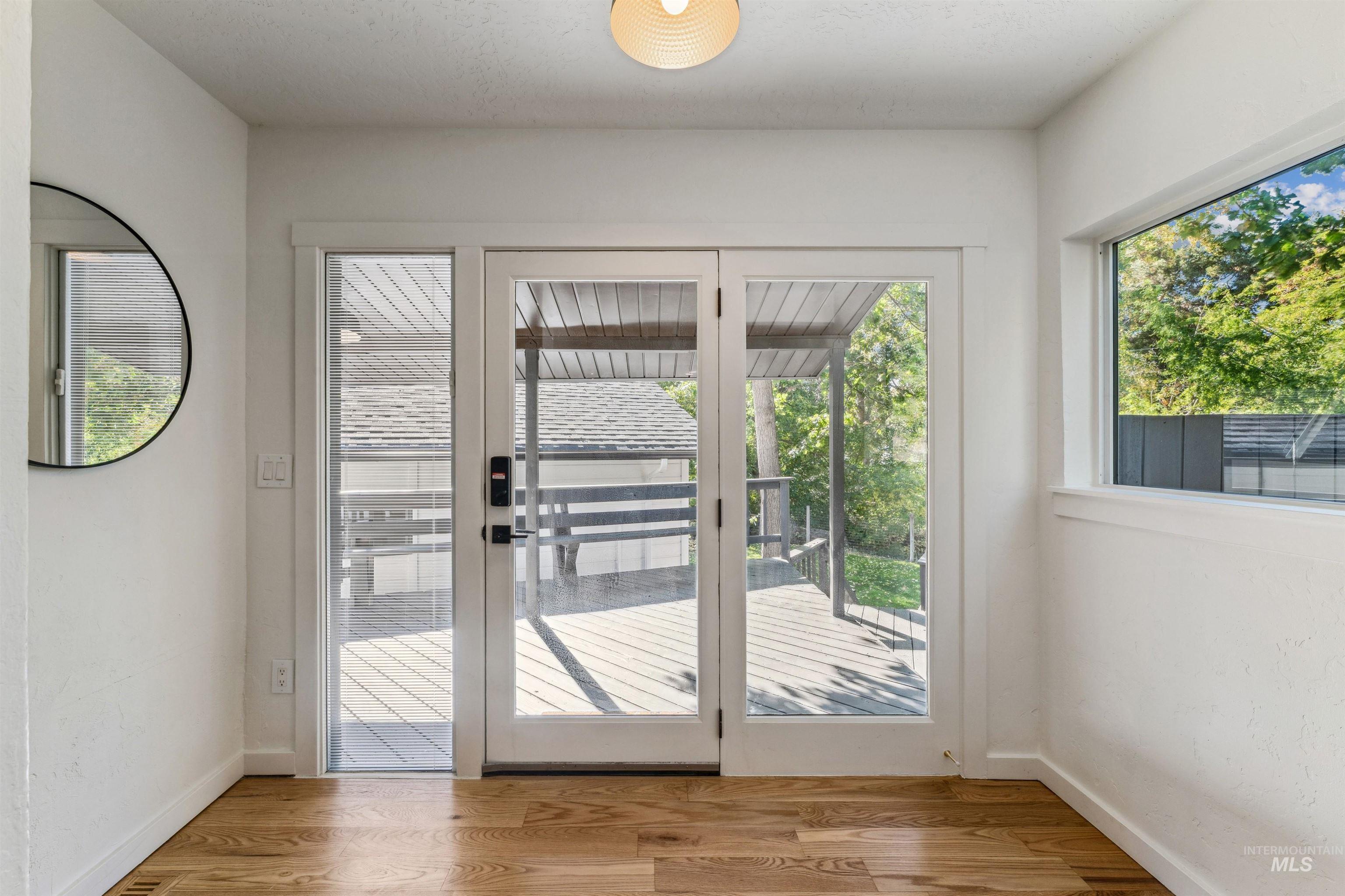 Entryway featuring french doors, wood finished floors, and healthy amount of natural light