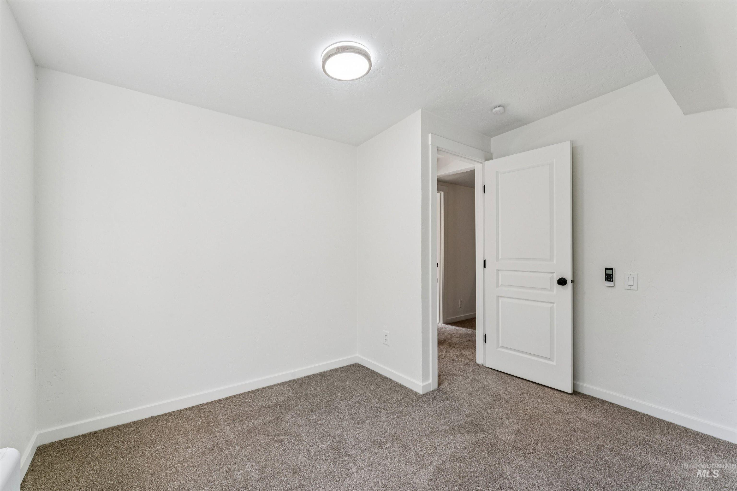 Unfurnished bedroom featuring carpet flooring and baseboards