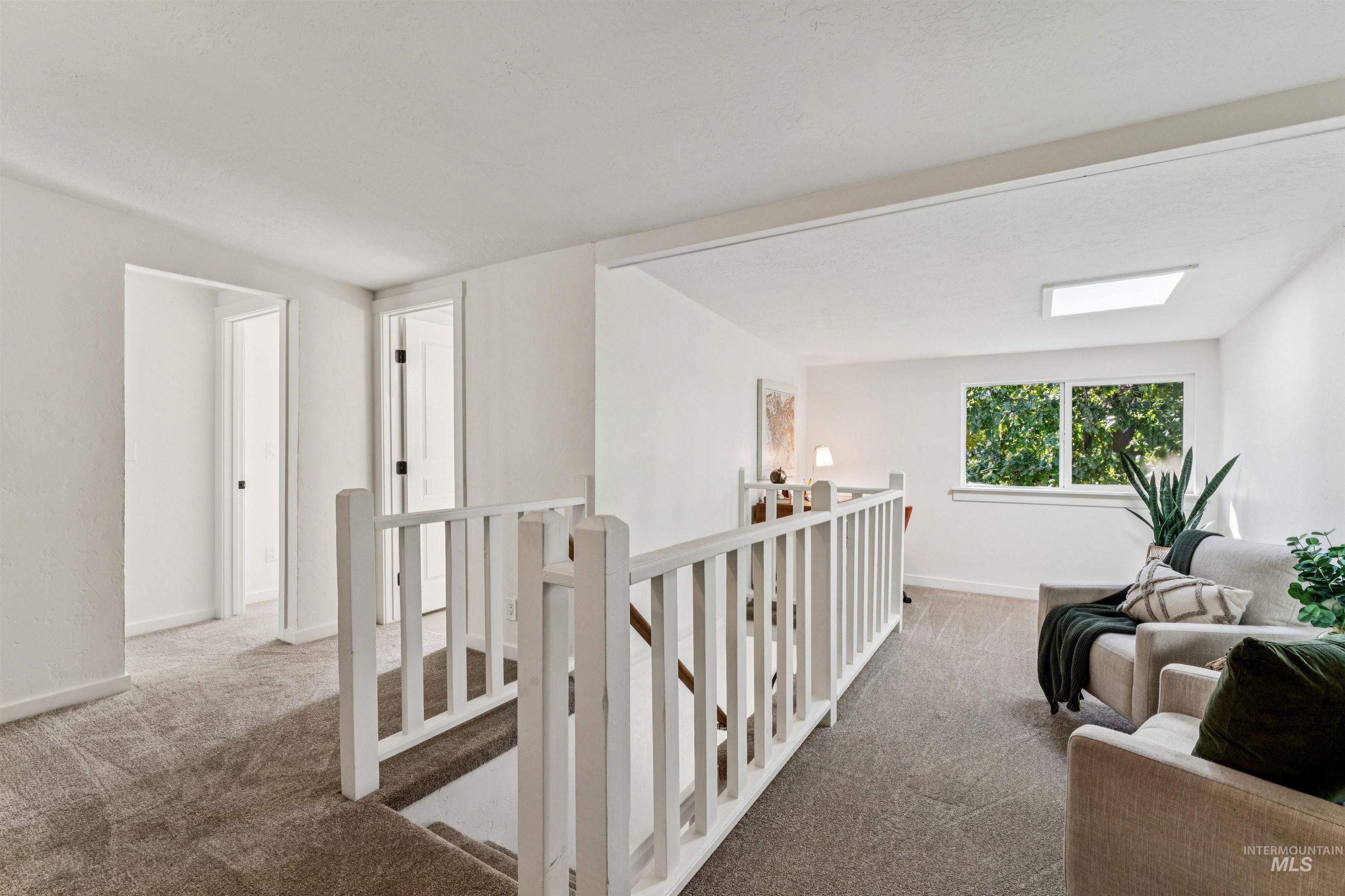 Hallway featuring an upstairs landing and carpet flooring
