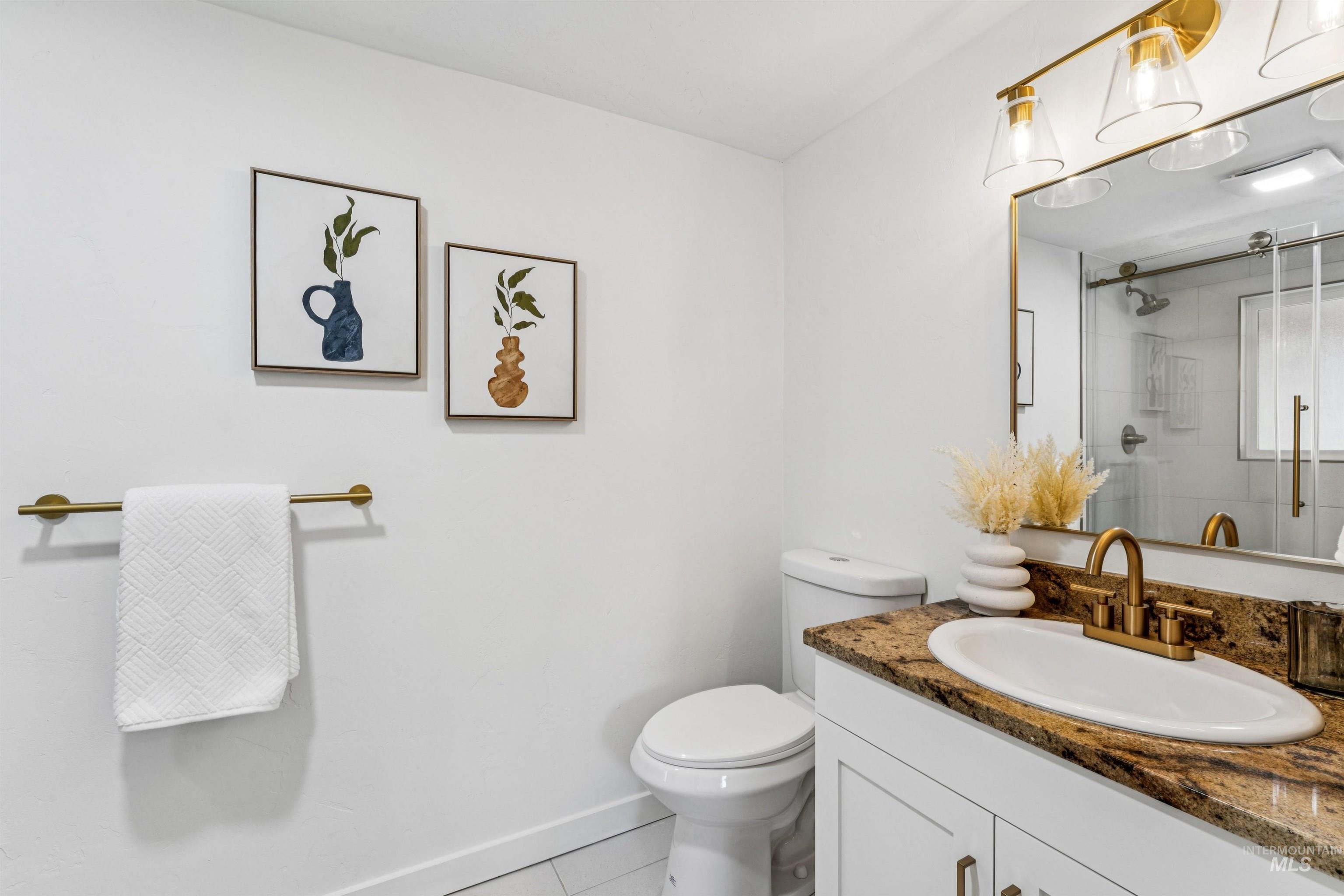 Primary bath with light tile patterned flooring, vanity, and a stall shower