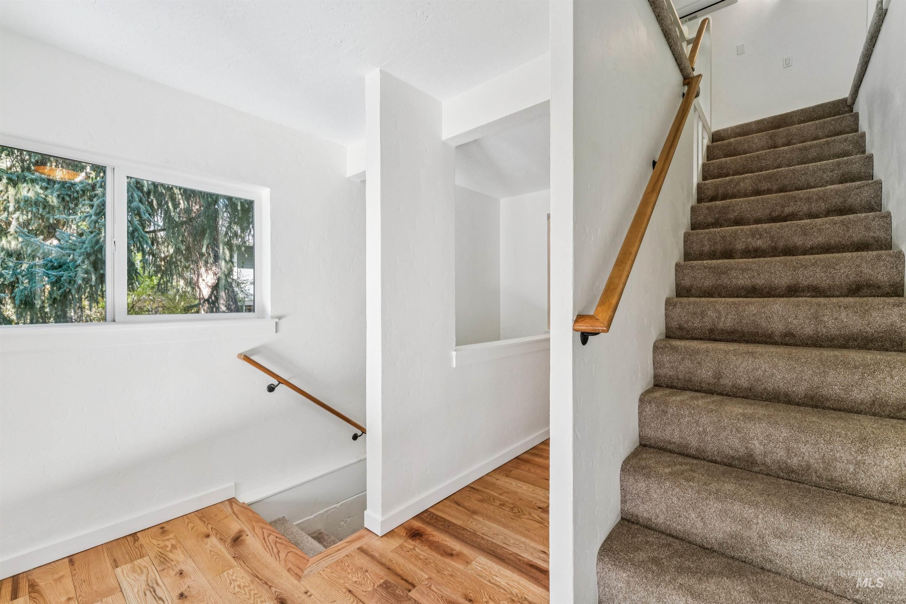Stairs with wood finished floors and baseboards