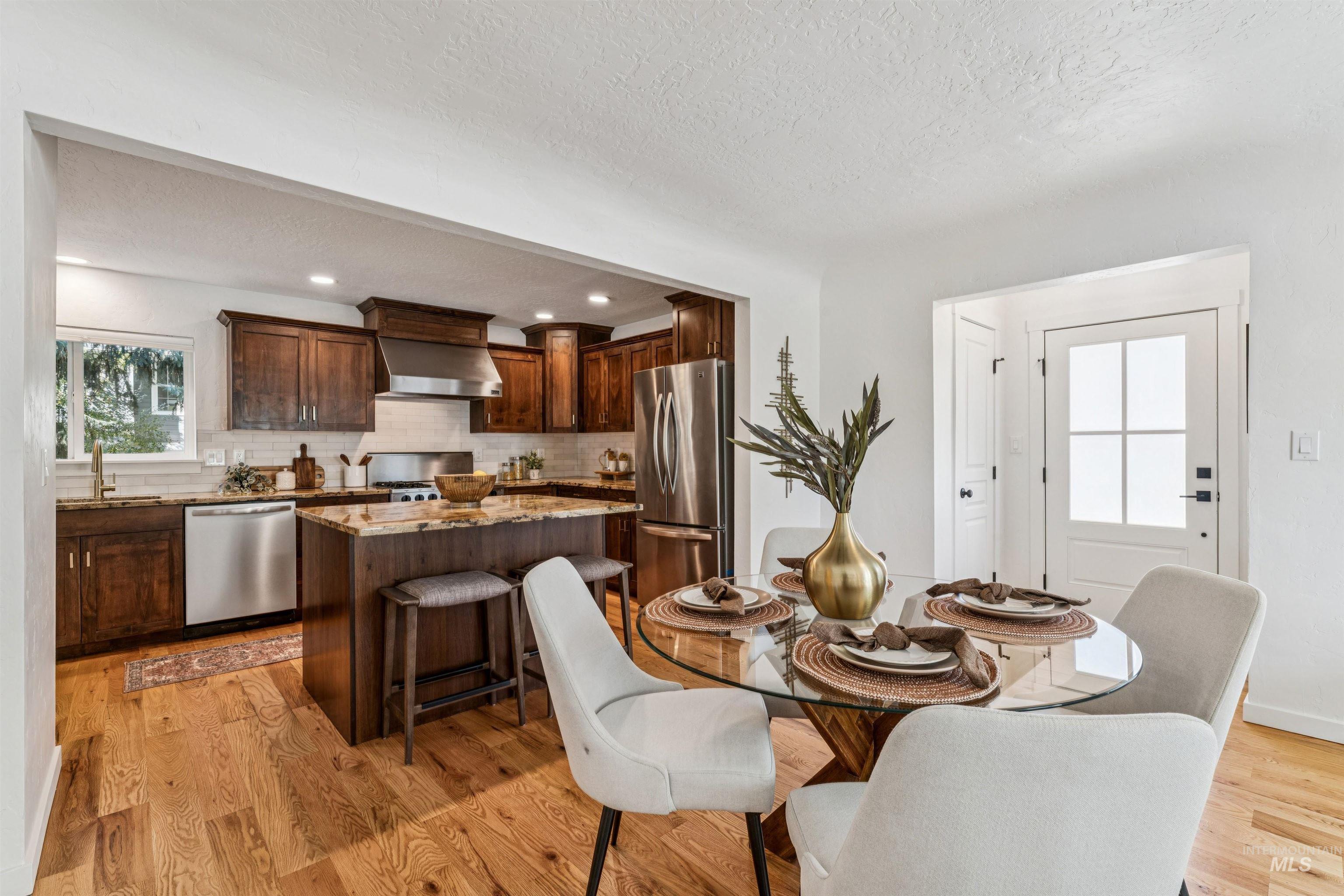 Dining room with plenty of natural light, a textured ceiling, light wood finished floors, and recessed lighting